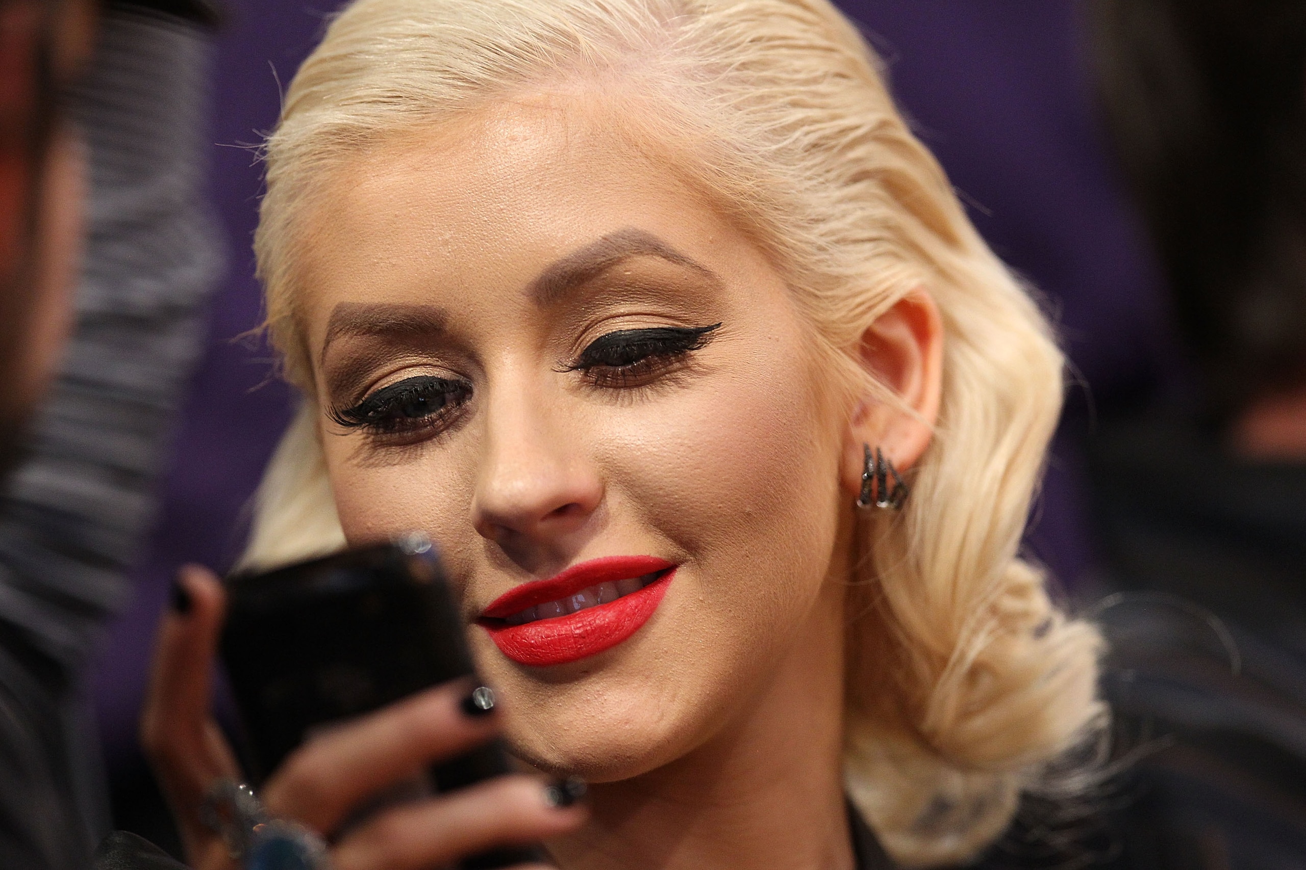 LOS ANGELES, CA - JUNE 15:  Singer Christina Aguilera looks at her cell phone while sitting courtside during Game Six of the 2010 NBA Finals between the Los Angeles Lakers and the Boston Celtics at Staples Center on June 15, 2010 in Los Angeles, Californi