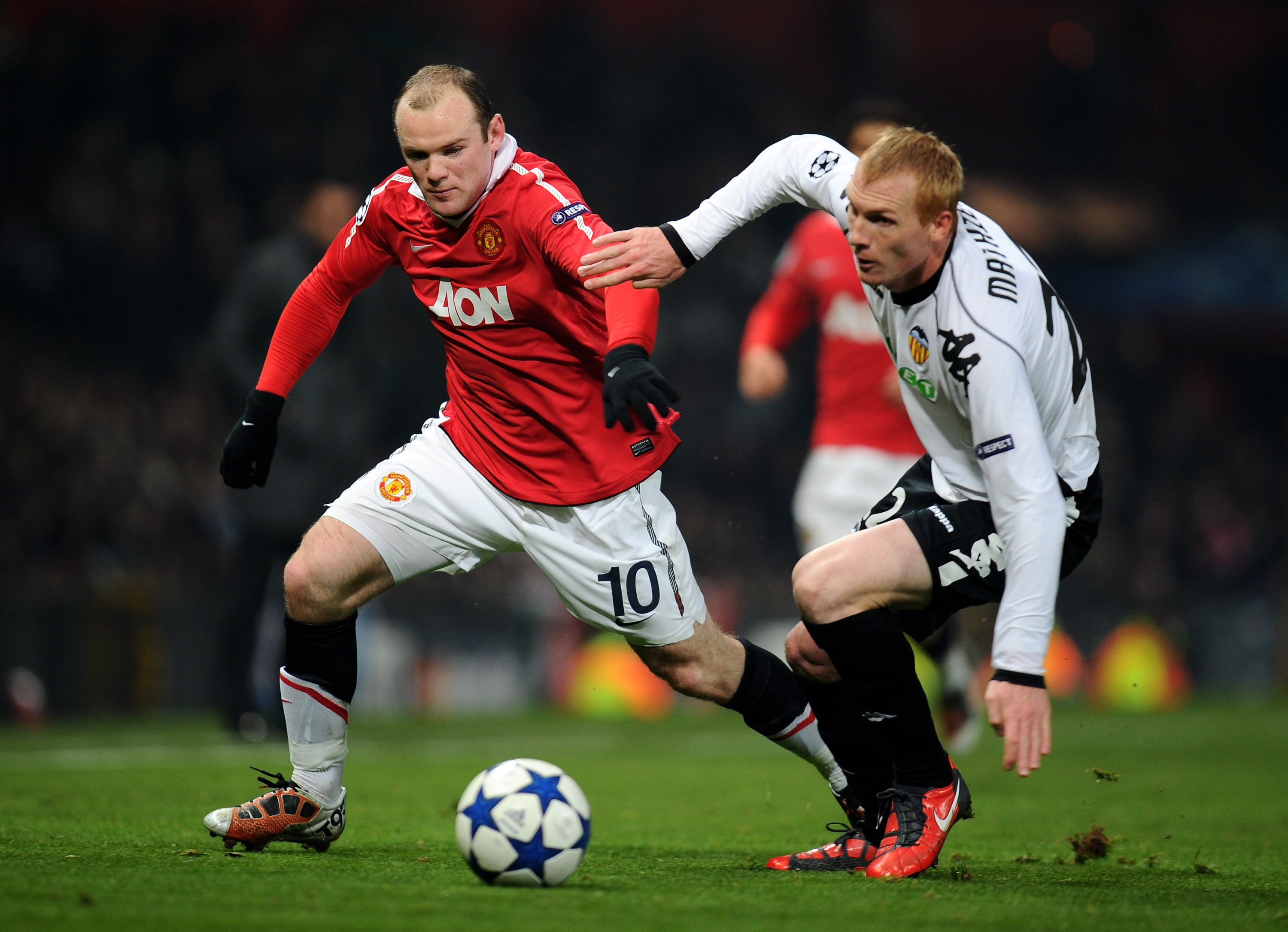 MANCHESTER, ENGLAND - DECEMBER 07:  Jeremy Mathieu of Valencia challenges Wayne Rooney of Manchester United during the UEFA Champions League Group C match between Manchester United and Valencia at Old Trafford on December 7, 2010 in Manchester, England.