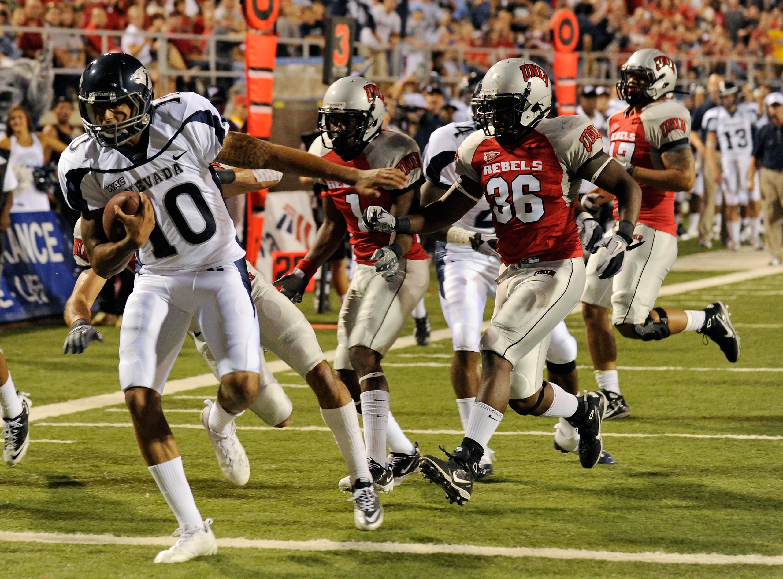 LAS VEGAS - OCTOBER 02:  Quarterback Colin Kaepernick #10 of the Nevada Reno Wolf Pack crosses the goal line ahead of UNLV Rebel defenders to score a touchdown in the first quarter of their game at Sam Boyd Stadium October 2, 2010 in Las Vegas, Nevada.  (