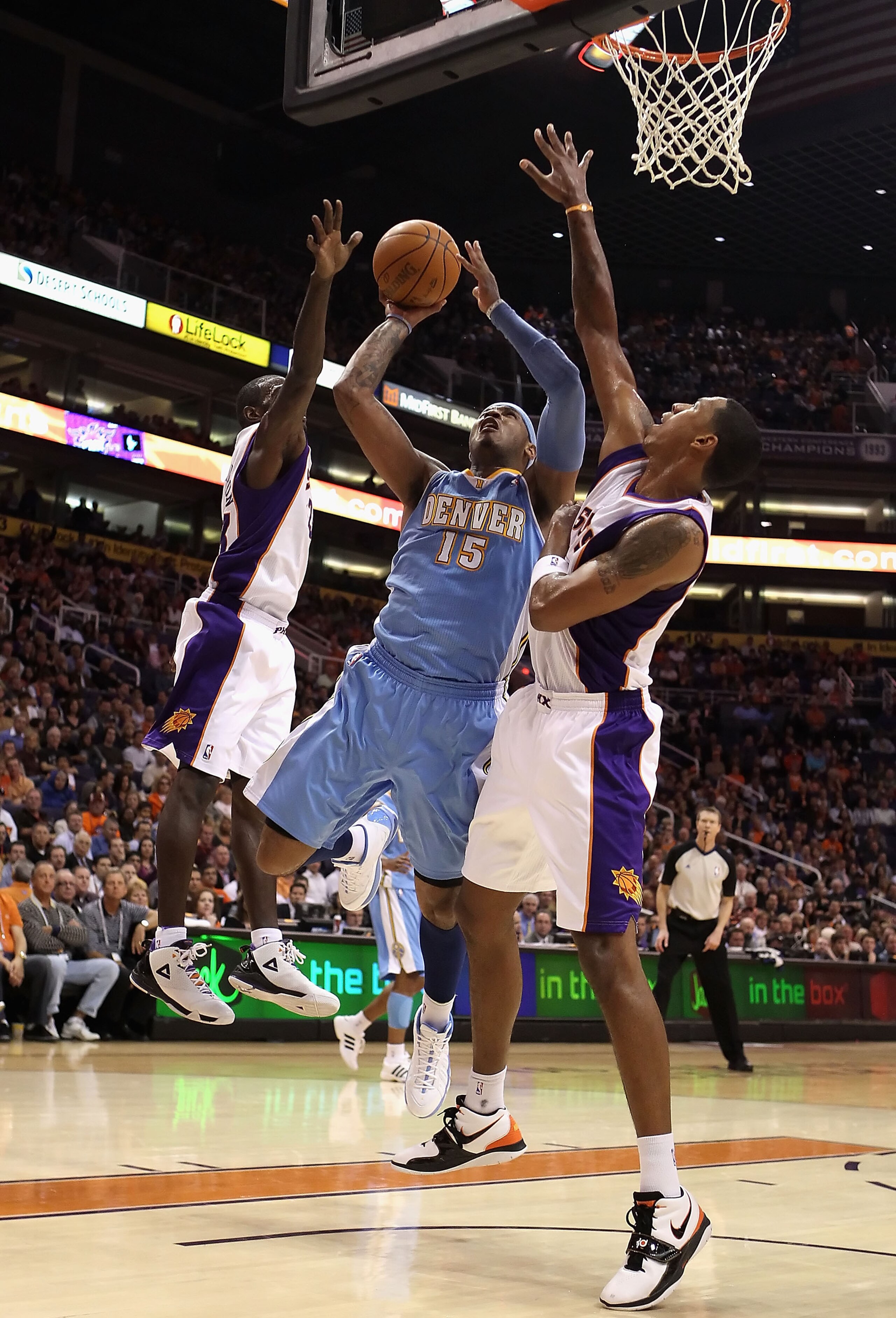 PHOENIX - NOVEMBER 15: Carmelo Anthony #15 of the Denver Nuggets puts up a shot against Jason Richardson #23 and Channing Frye #8 of the Phoenix Suns during the NBA game at US Airways Center on November 15, 2010 in Phoenix, Arizona. The Suns defeated th PHOENIX - NOVEMBER 15: Carmelo Anthony #15 of the Denver Nuggets puts up a shot against Jason Richardson #23 and Channing Frye #8 of the Phoenix Suns during the NBA game at US Airways Center on November 15, 2010 in Phoenix, Arizona. The Suns defeated th