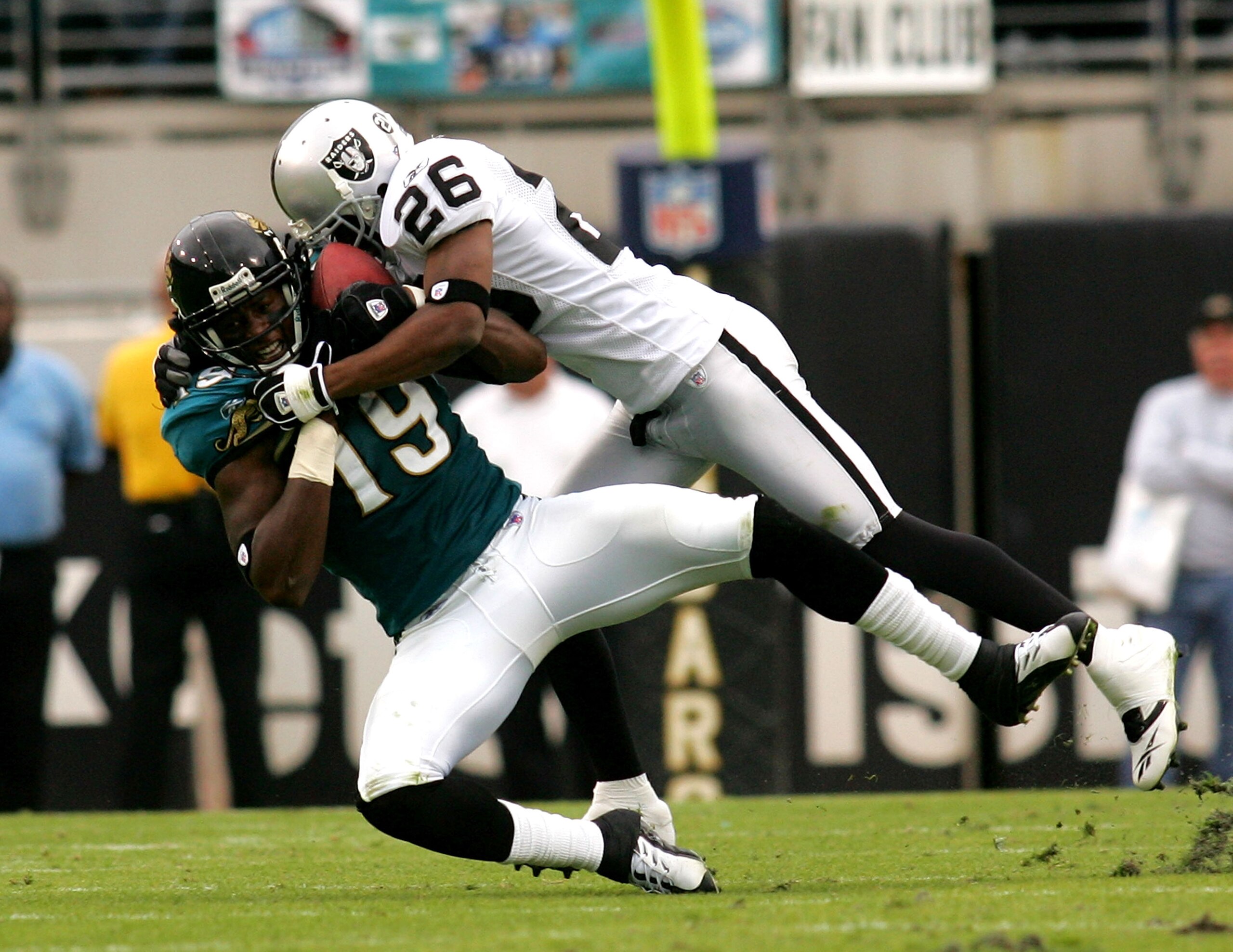 JACKSONVILLE, FL - DECEMBER 23:  Ernest Wilford #19 of the Jacksonville Jaguars is tackled by Stanford Routt #26 of the Oakland Raiders at Jacksonville Municipal Stadium on December 23, 2007 in Jacksonville, Florida.  (Photo by Sam Greenwood/Getty Images)