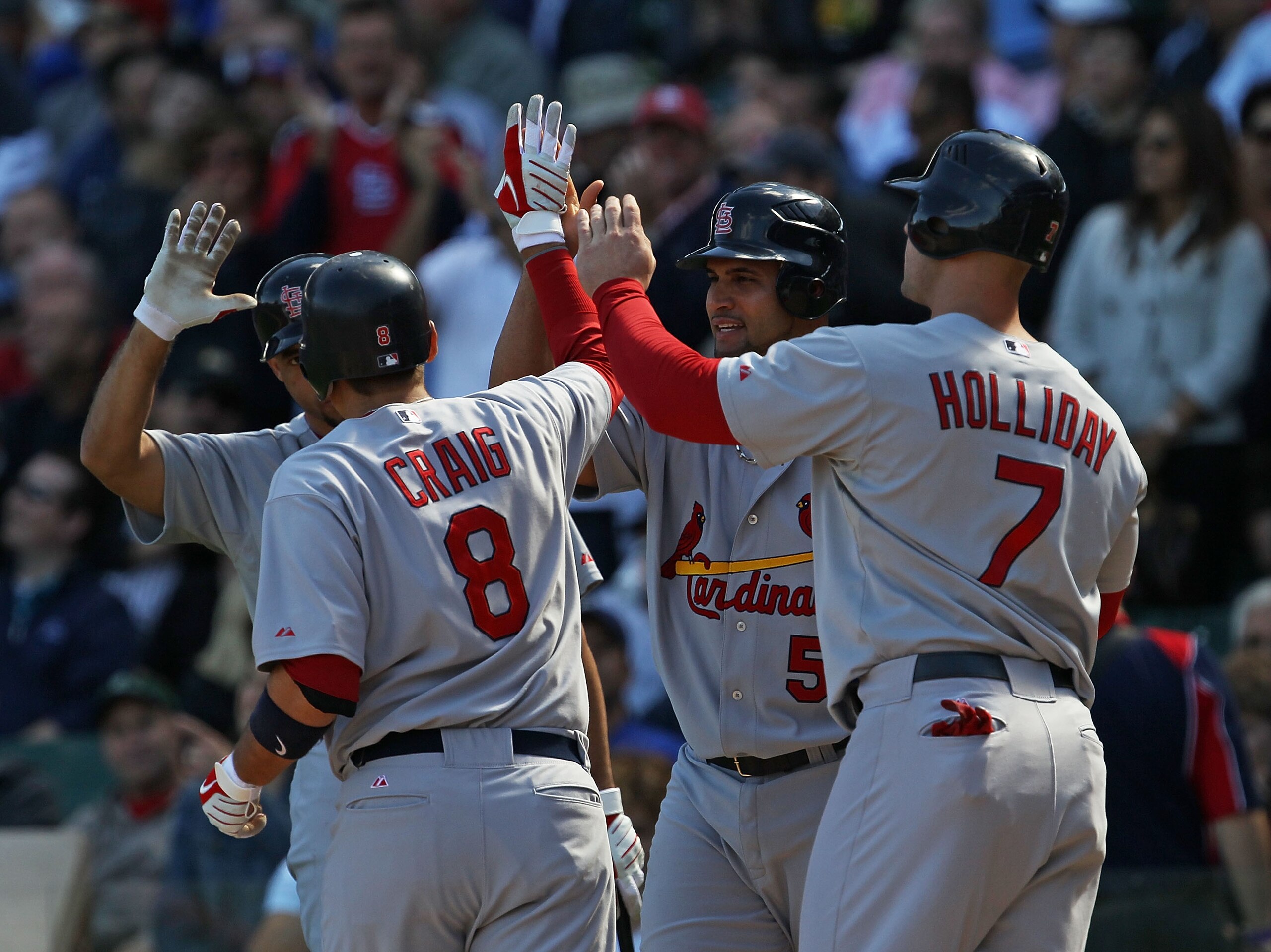 CHICAGO - SEPTEMBER 24: Allen Craig #8 of the St. Louis Cardinals is congratulated by (L-R) Pedro Feliz #77, Albert Pujols #5 and Matt Holliday #7 after hitting a three-run home run in the 1st inning against the Chicago Cubs at Wrigley Field on September 