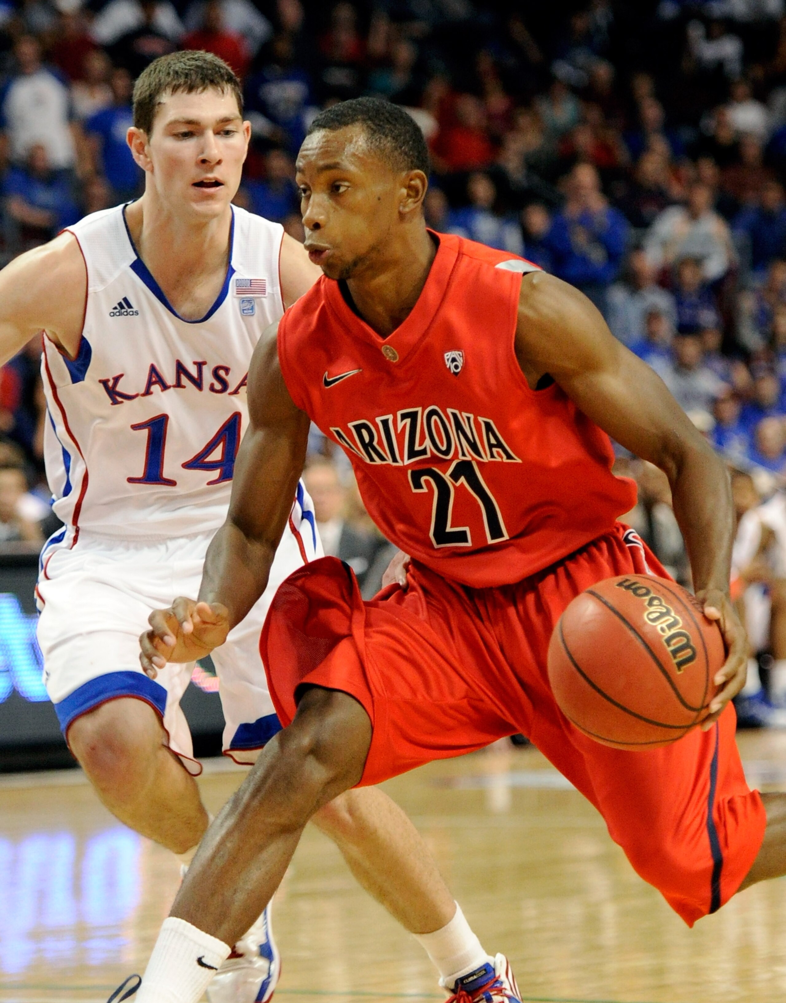 LAS VEGAS - NOVEMBER 27:  Kyle Fogg #21 of the Arizona Wildcats drives against Tyrel Reed #14 of the Kansas Jayhawks during the championship game of the Las Vegas Invitational at The Orleans Arena November 27, 2010 in Las Vegas, Nevada. Kansas won 87-79. 