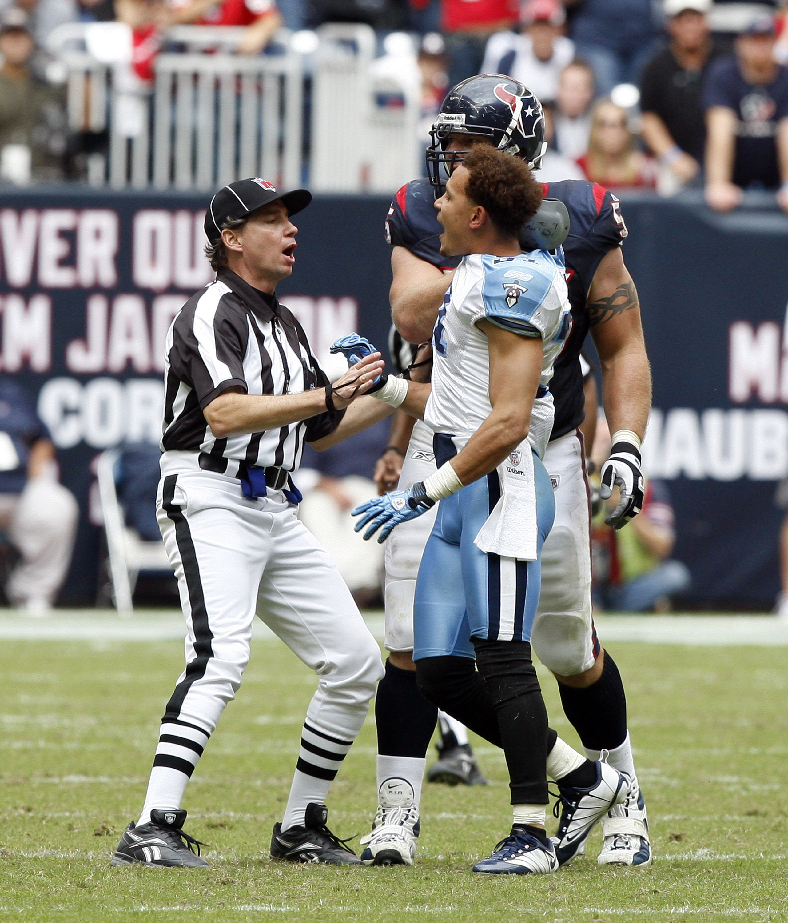 HOUSTON - NOVEMBER 28:  Cornerback Cortland Finnegan #31 of the Tennessee Titans is held back by an official after getting into a fight with Andre Johnson of the Houston Texans at Reliant Stadium on November 28, 2010 in Houston, Texas.  (Photo by Bob Leve