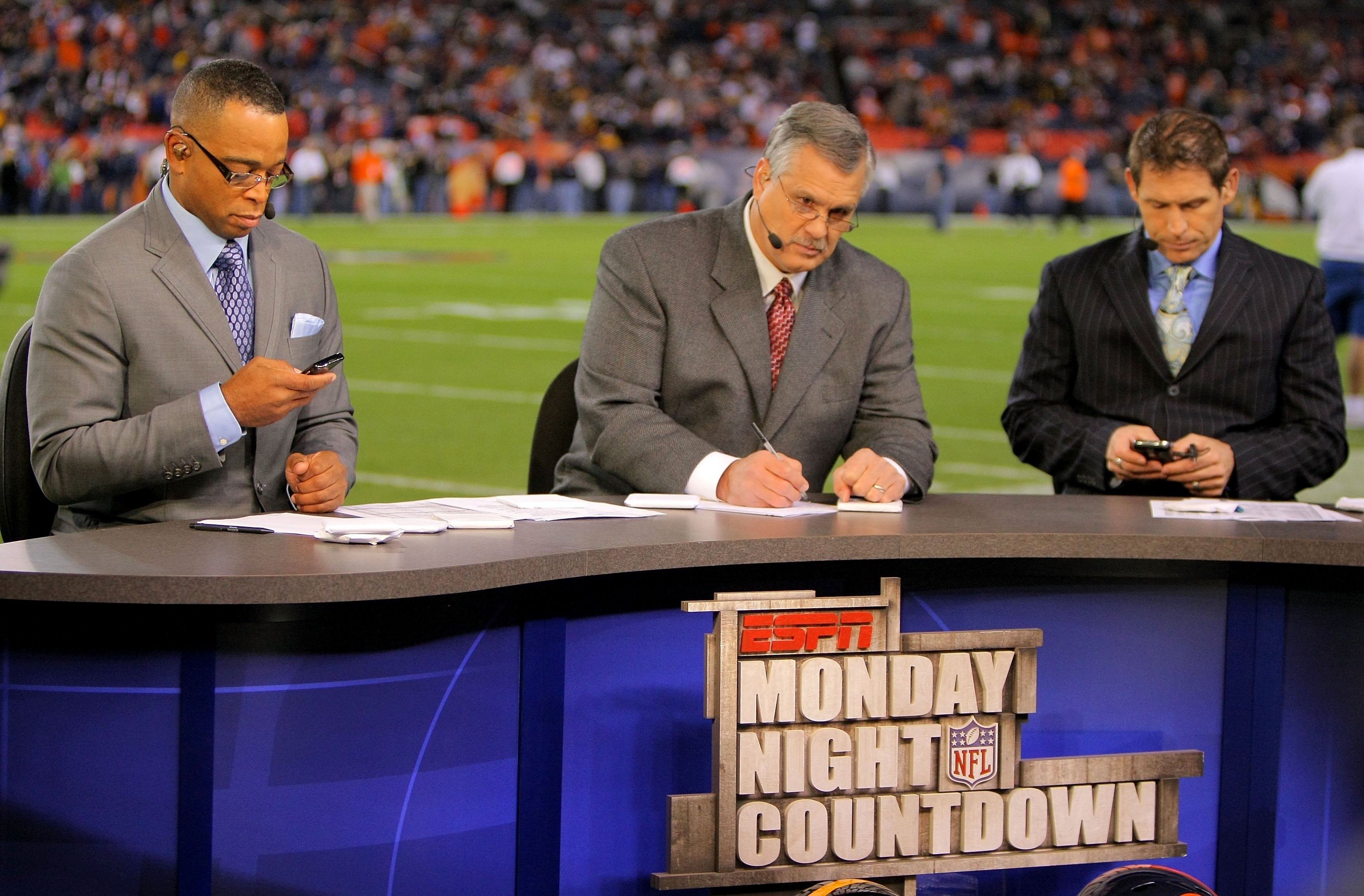DENVER - NOVEMBER 09:  Matt Millen (C) works on the set of the pregame show for ESPN's Monday Night Football as his co hosts Stuart Scott (L) and Steve Young (R) work on their personal electronic devices as the Pittsburgh Steelers face the Denver Broncos 