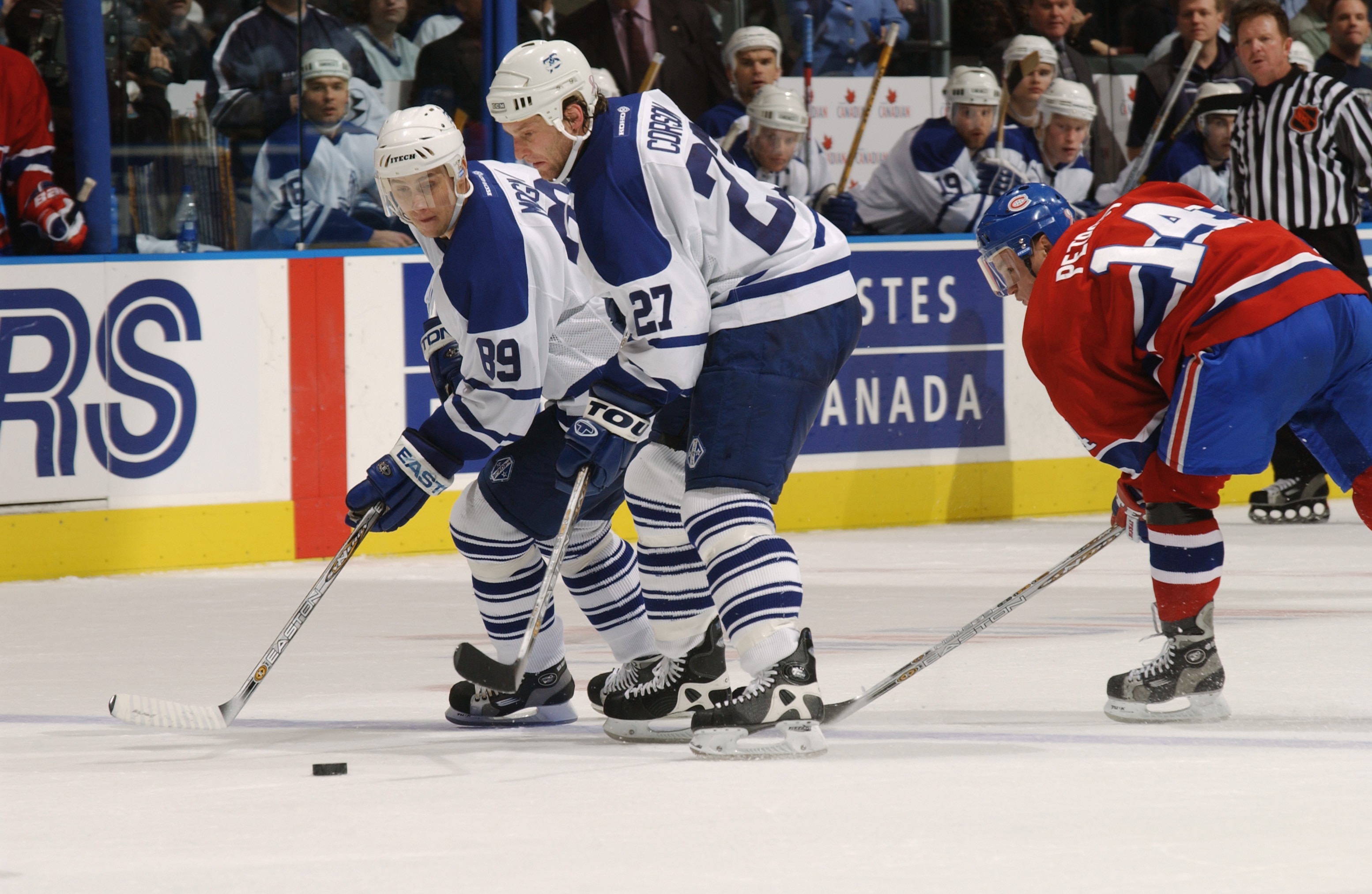 TORONTO - JANUARY 12:  Right wing Alexander Mogilny #89 of the Toronto Maple Leafs and left wing Shayne Corson #27 shield the puck from right wing Oleg Petrov #14 of the Montreal Canadiens during the NHL game at Air Canada Centre in Toronto, Canada on Jan