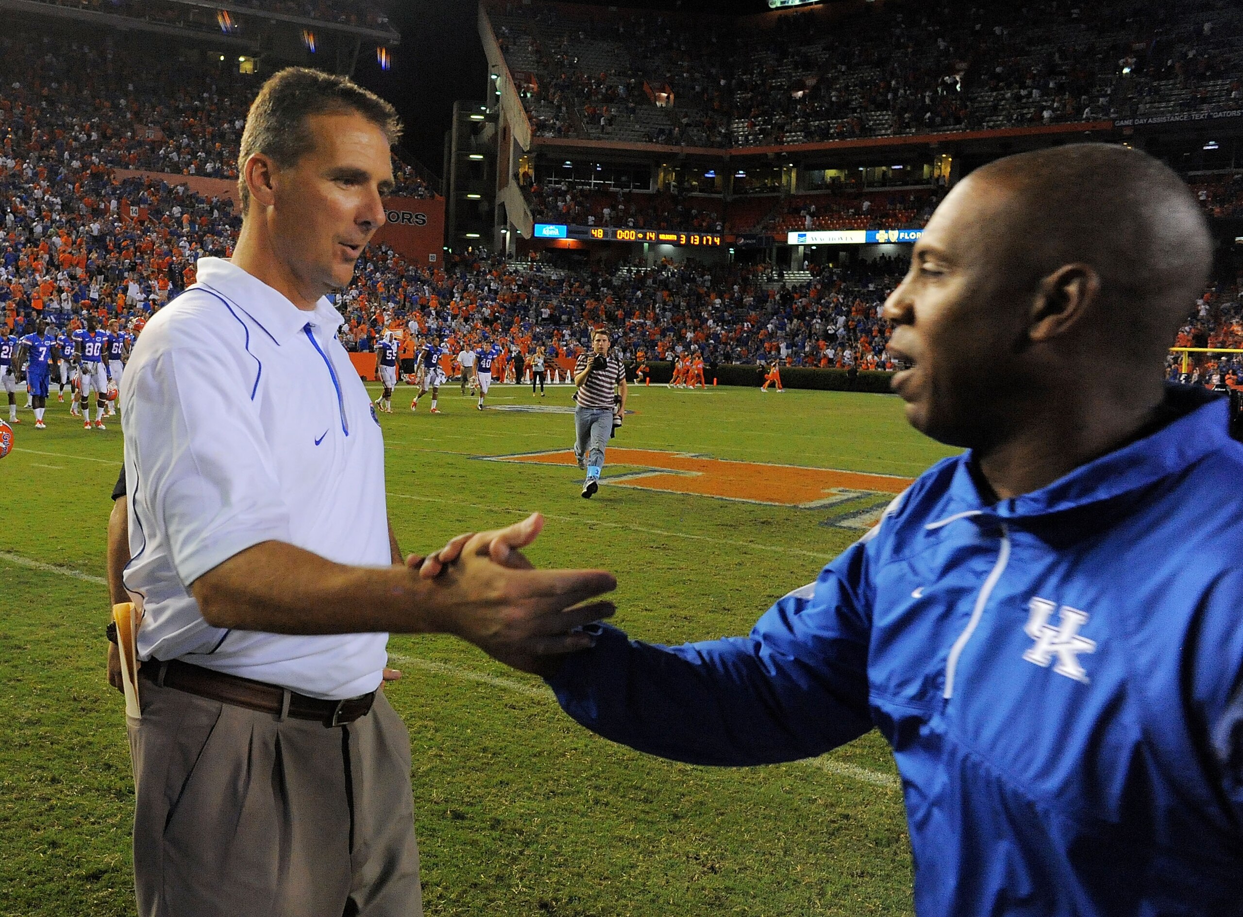 GAINESVILLE, FL - SEPTEMBER 25:  Head coach Urban Meyer of the Florida Gators is congratulated by head coach Joker Phillips of the Kentucky Wildcats at Ben Hill Griffin Stadium on September 25, 2010 in Gainesville, Florida. Florida defeated Kentucky 48-14