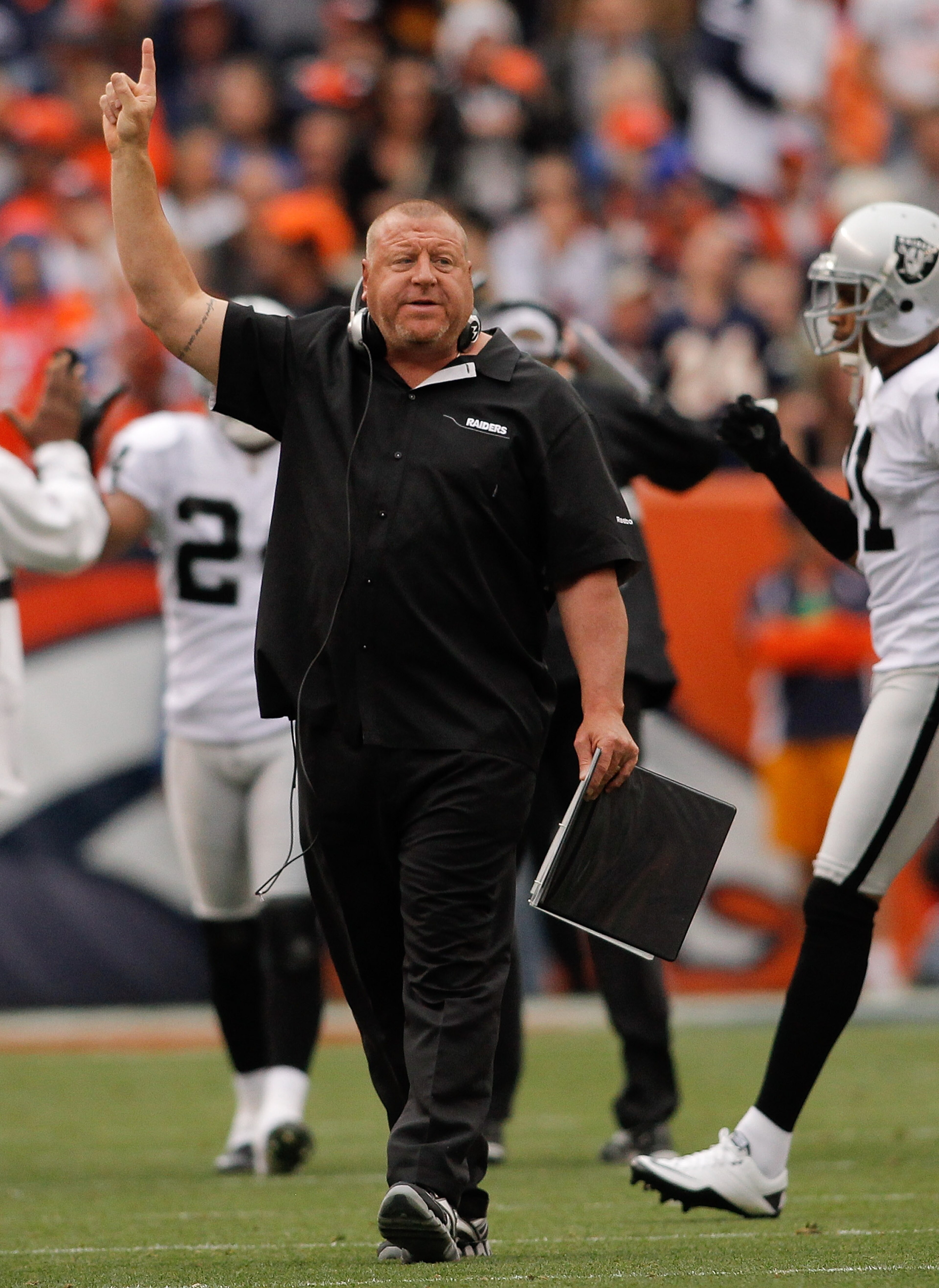 DENVER - OCTOBER 24:  Head coach Tom Cable of the Oakland Raiders signals for an extra point following a touchdown against the Denver Broncos in the first quarter at INVESCO Field at Mile High on October 24, 2010 in Denver, Colorado. The Raiders defeated