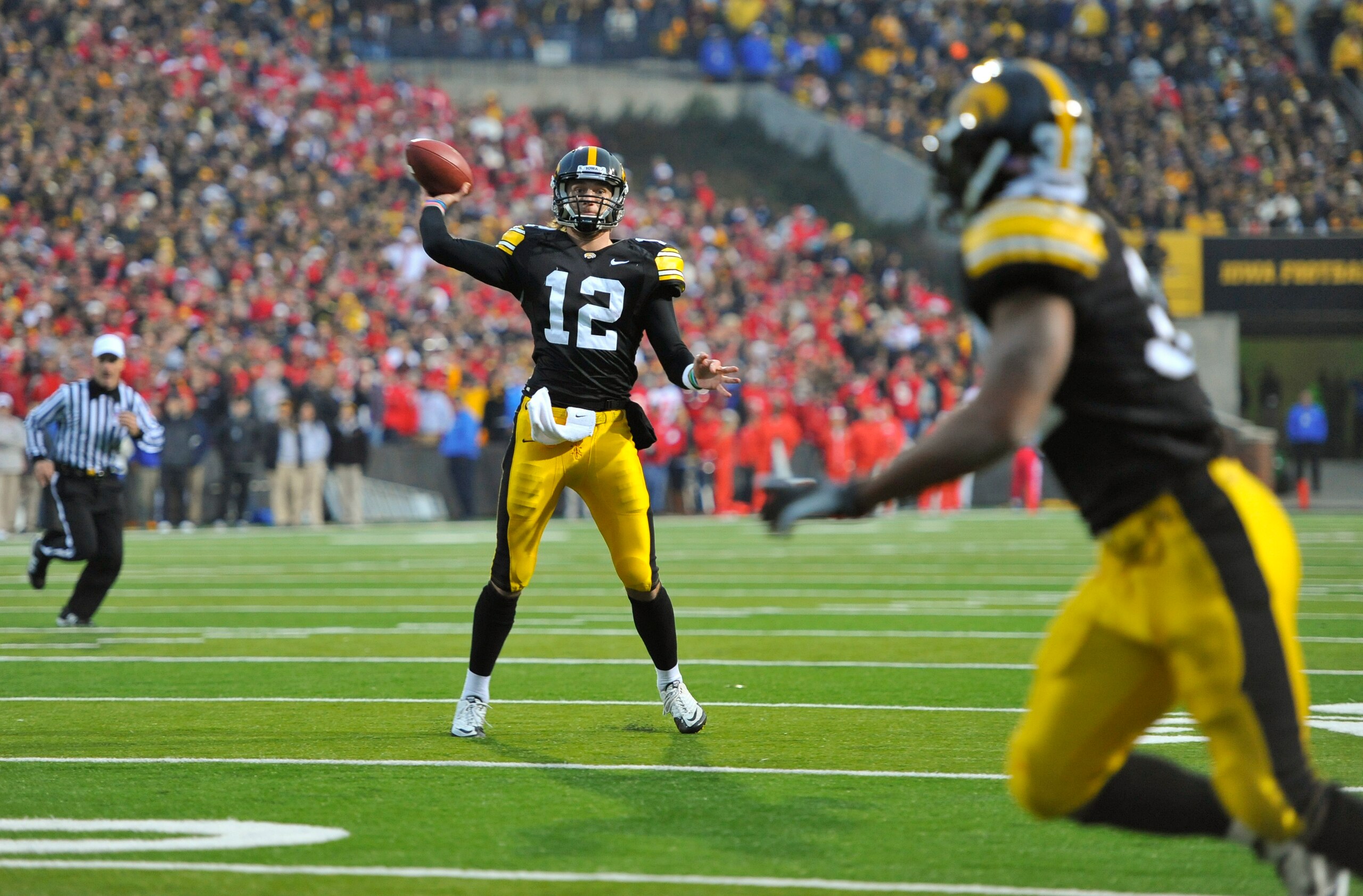 IOWA CITY, IA - NOVEMBER 20:  Quarterback Ricky Stanzi #12 of the University of Iowa Hawkeyes throws down field to running back Adam Robinson #32 during the second half of play against the Ohio State Buckeyes at Kinnick Stadium on November 20, 2010 in Iow