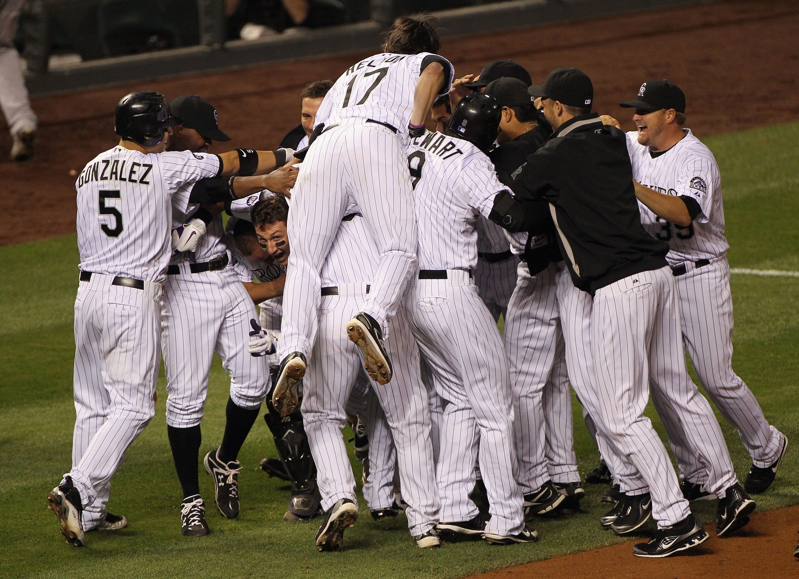 DENVER - SEPTEMBER 25:  Troy Tulowitzki #2 of the Colorado Rockies begins to emerge from the pile up as he hit the game RBI double to score Carlos Gonzalez #5 against the San Francisco Giants in the 10th inning at Coors Field on September 25, 2010 in Denv