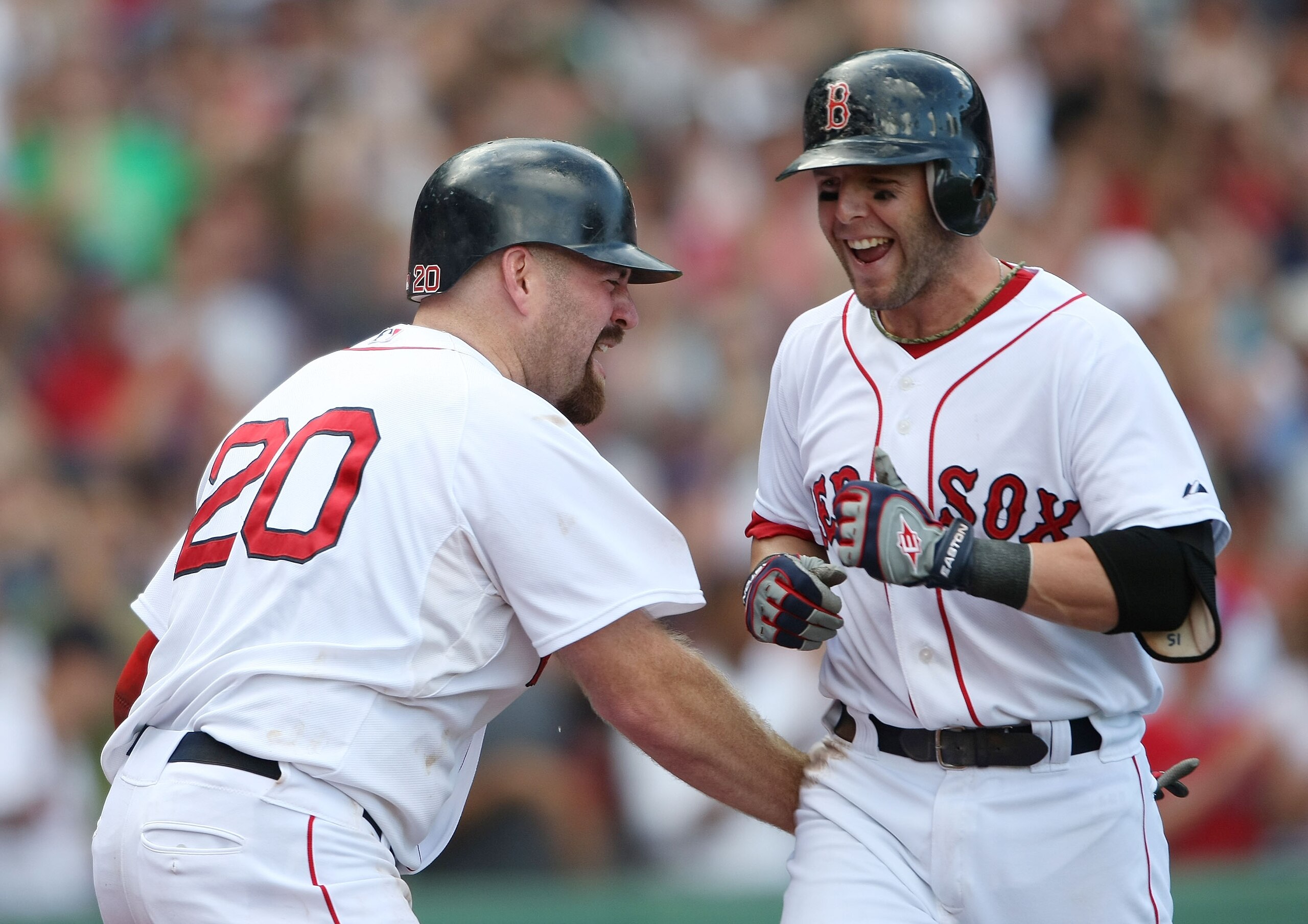 BOSTON - SEPTEMBER 13:  Dustin Pedroia #15 of the Boston Red Sox is congratulated by teammate Kevin Youkils #20 after Pedroia hit the game winning home run against the Tampa Bay Rays on September 13, 2009 at Fenway Park in Boston, Massachusetts. Pedroia d