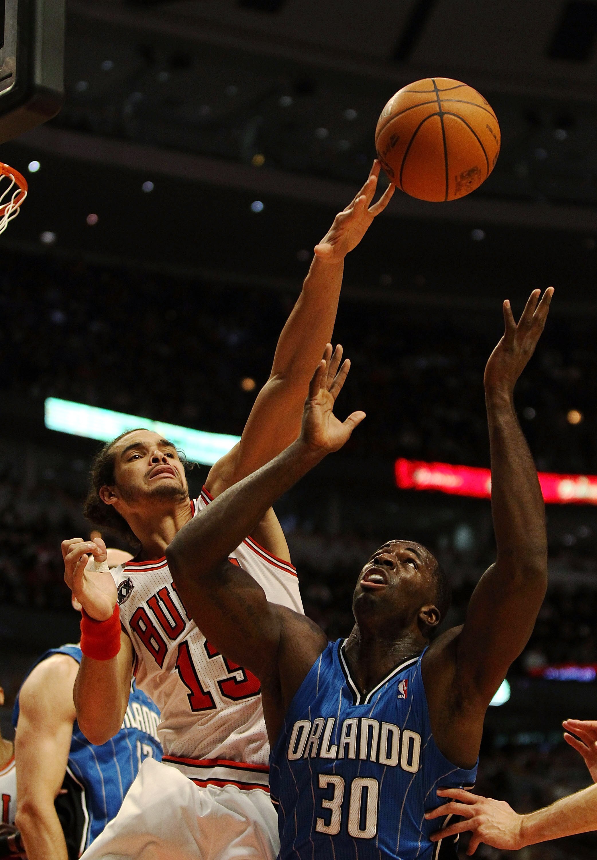 CHICAGO, IL - DECEMBER 01: Joakim Noah #13 of the Chicago Bulls knocks the ball away from Brandon Bass #30 of the Orlando Magic at the United Center on December 1, 2010 in Chicago, Illinois. NOTE TO USER: User expressly acknowledges and agrees that, by do