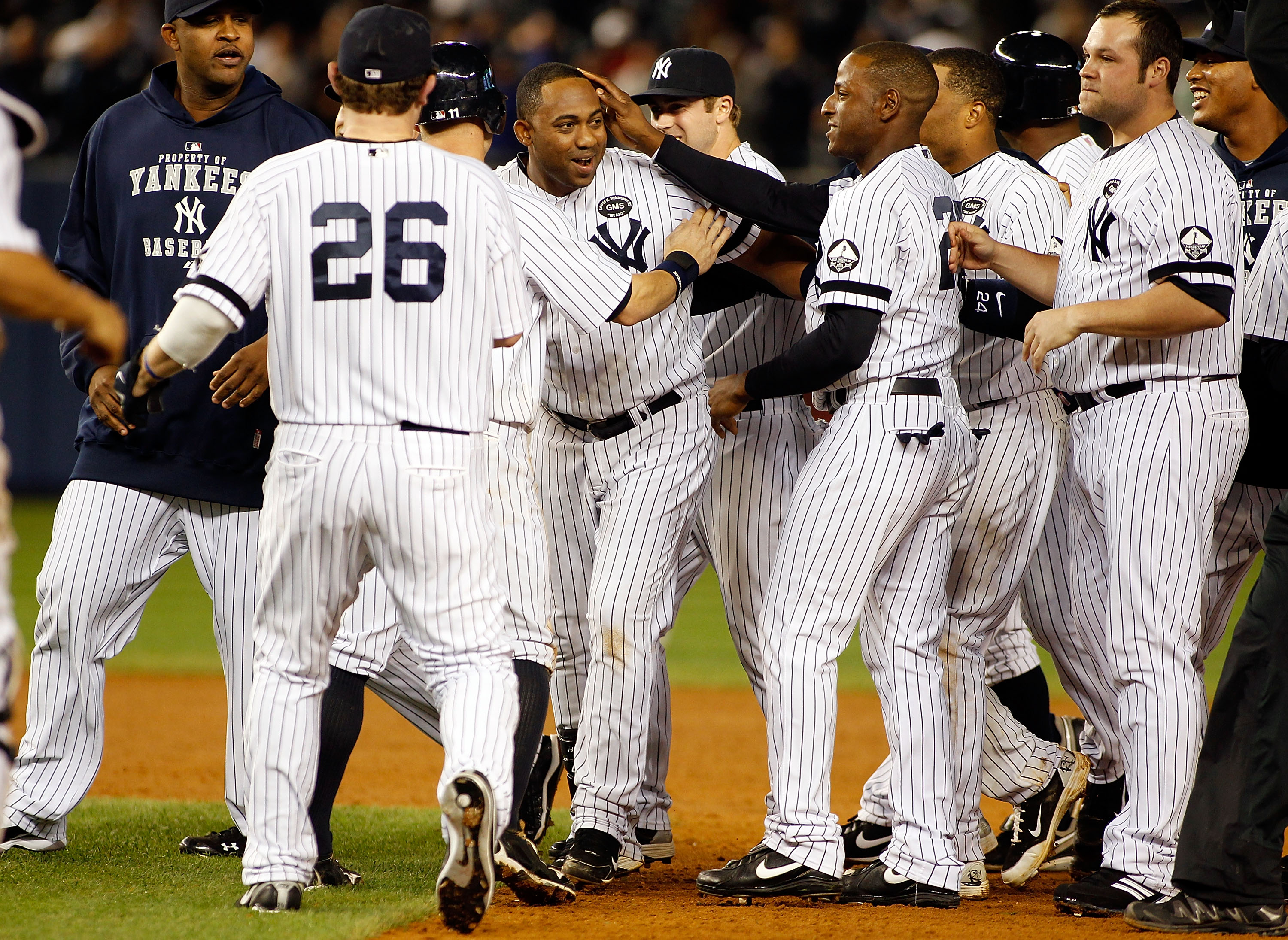 NEW YORK - SEPTEMBER 26:  Juan Miranda #53 of the New York Yankees is mobbed by his teammates after walking with the bases-loaded to force in the game winning run in the 10th inning against the Boston Red Sox on September 26, 2010 at Yankee Stadium in the