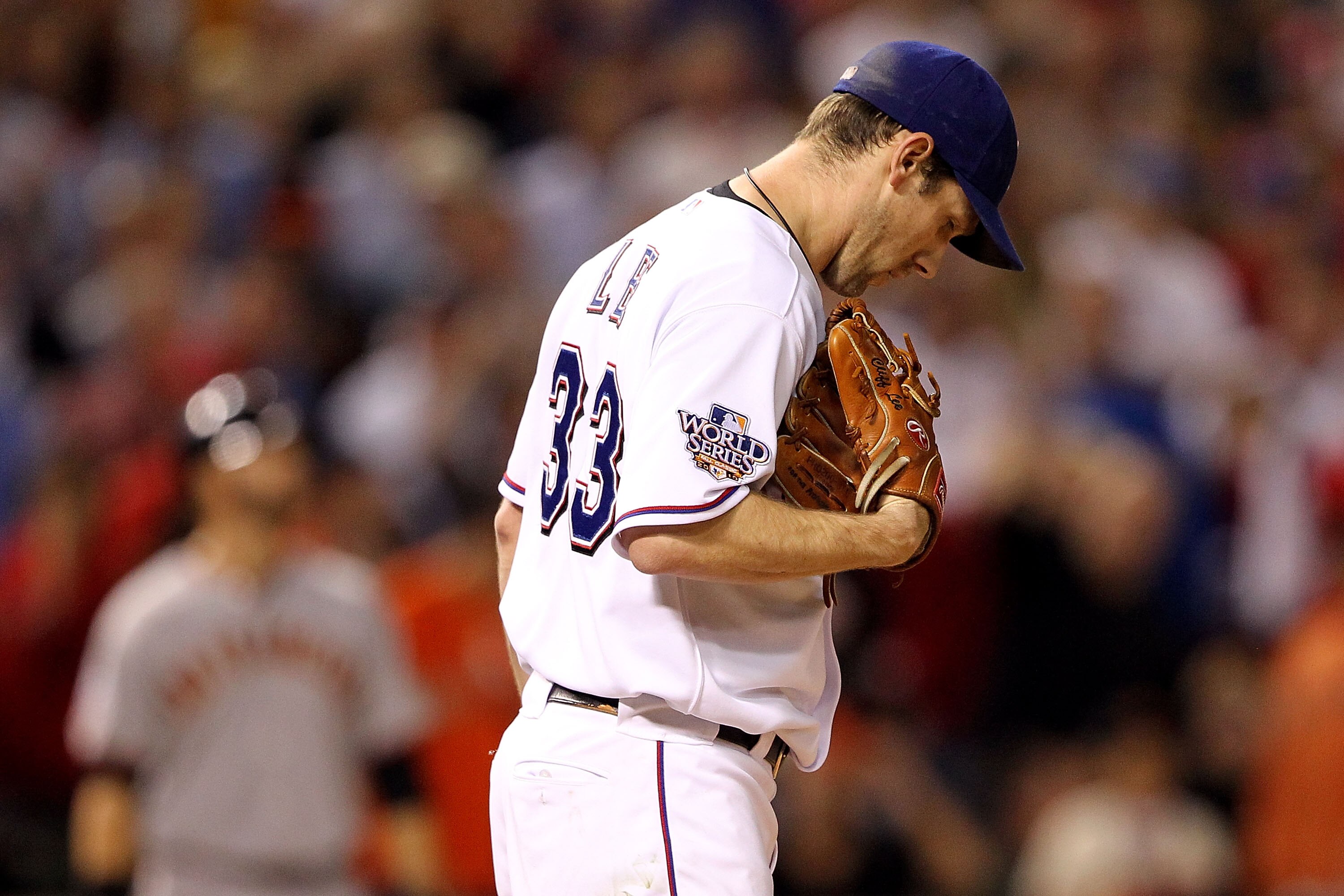 ARLINGTON, TX - NOVEMBER 01:  Cliff Lee #33 of the Texas Rangers stands on the mound with his head down as Cody Ross #13 of the San Francisco Giants stands on third base in Game Five of the 2010 MLB World Series at Rangers Ballpark in Arlington on Novembe