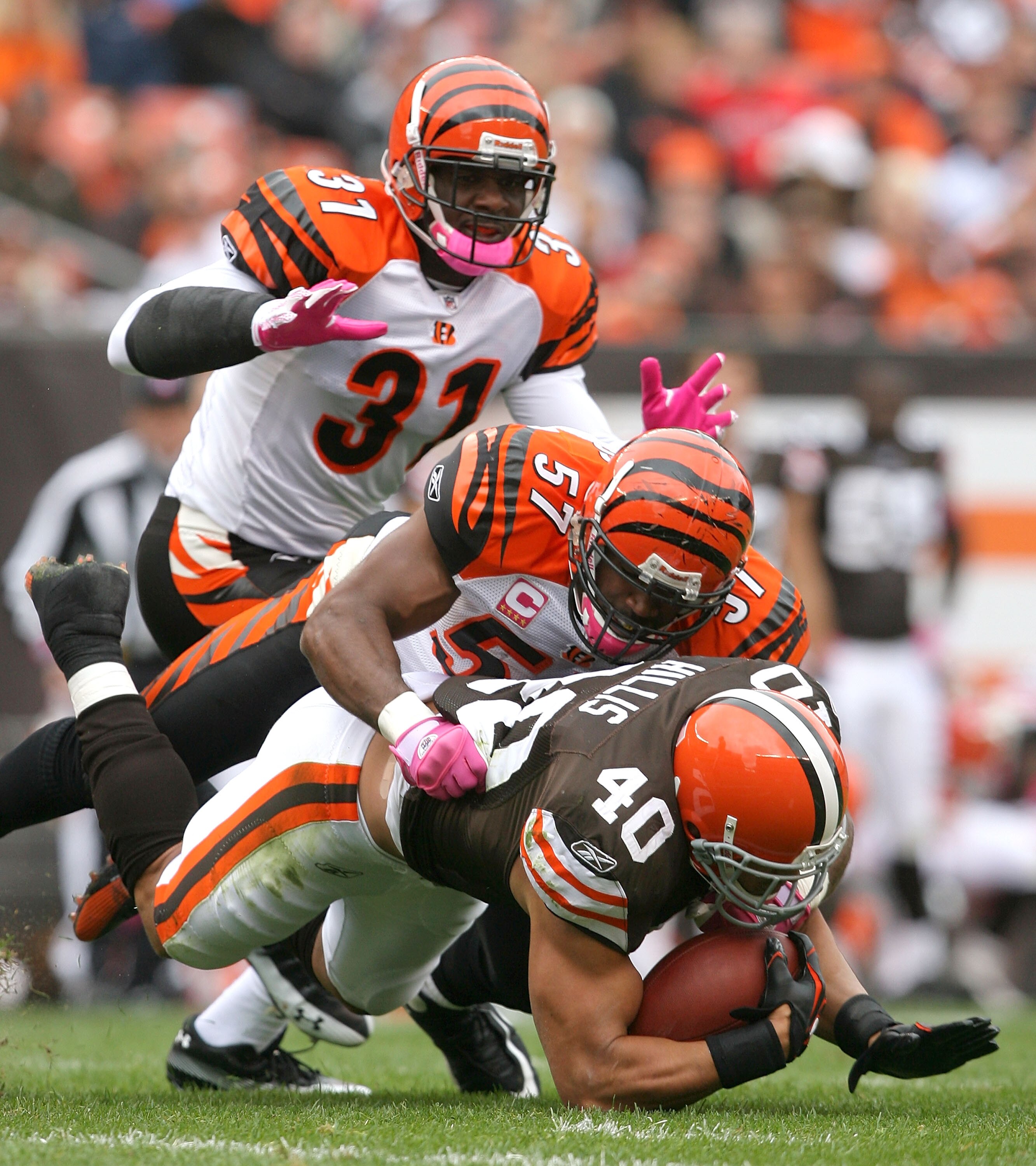 CLEVELAND - OCTOBER 03:  Defenders Roy Williams #31 and Dhani Jones #57 of the Cincinnati Bengals tackle running back Peyton Hillis #40 of the Cleveland Browns at Cleveland Browns Stadium on October 3, 2010 in Cleveland, Ohio.  (Photo by Matt Sullivan/Get