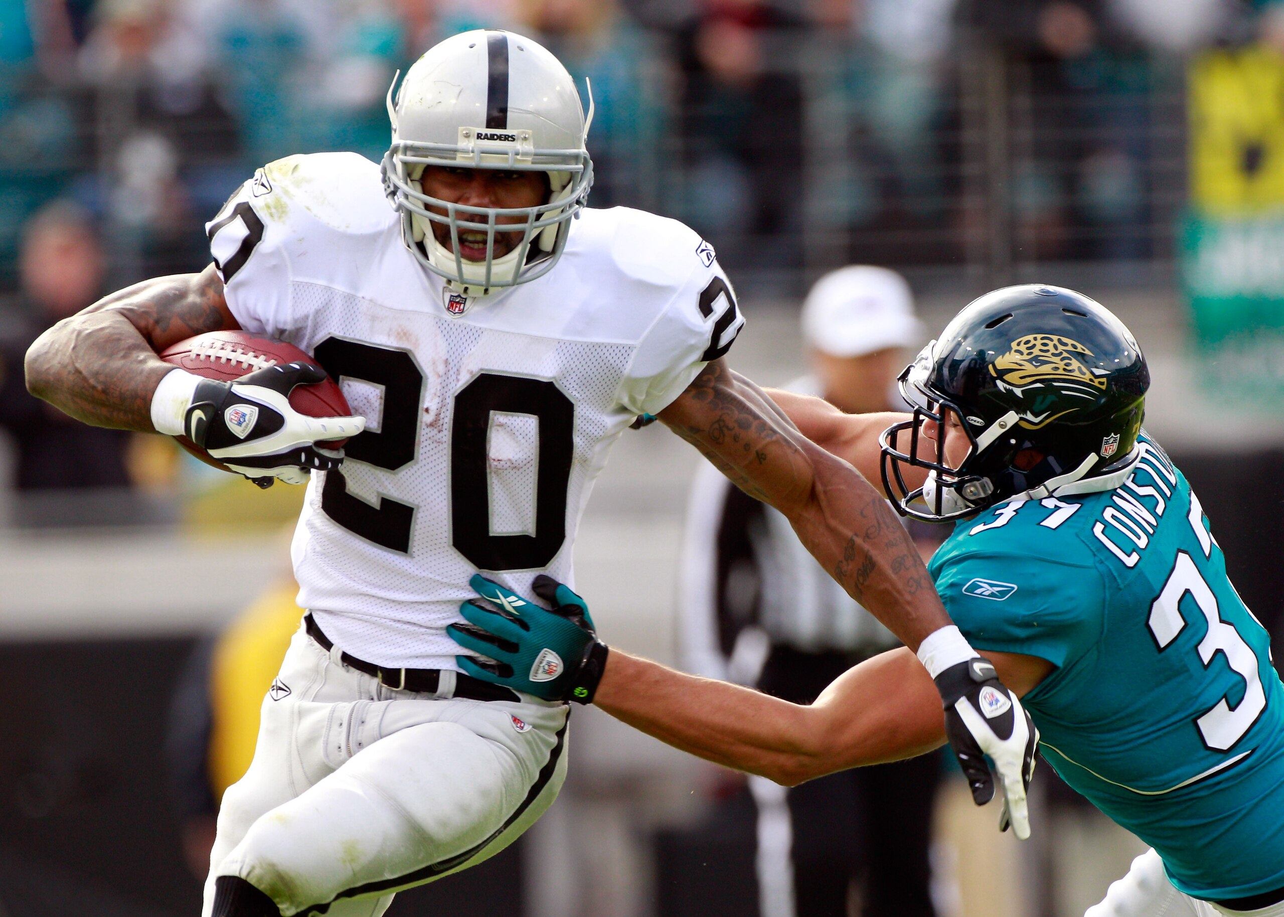 JACKSONVILLE, FL - DECEMBER 12:  Darren McFadden #20 of the Oakland Raiders breaks the tackle of Sean Considine #37 of the Jacksonville Jaguars during the game at EverBank Field on December 12, 2010 in Jacksonville, Florida.  (Photo by Sam Greenwood/Getty
