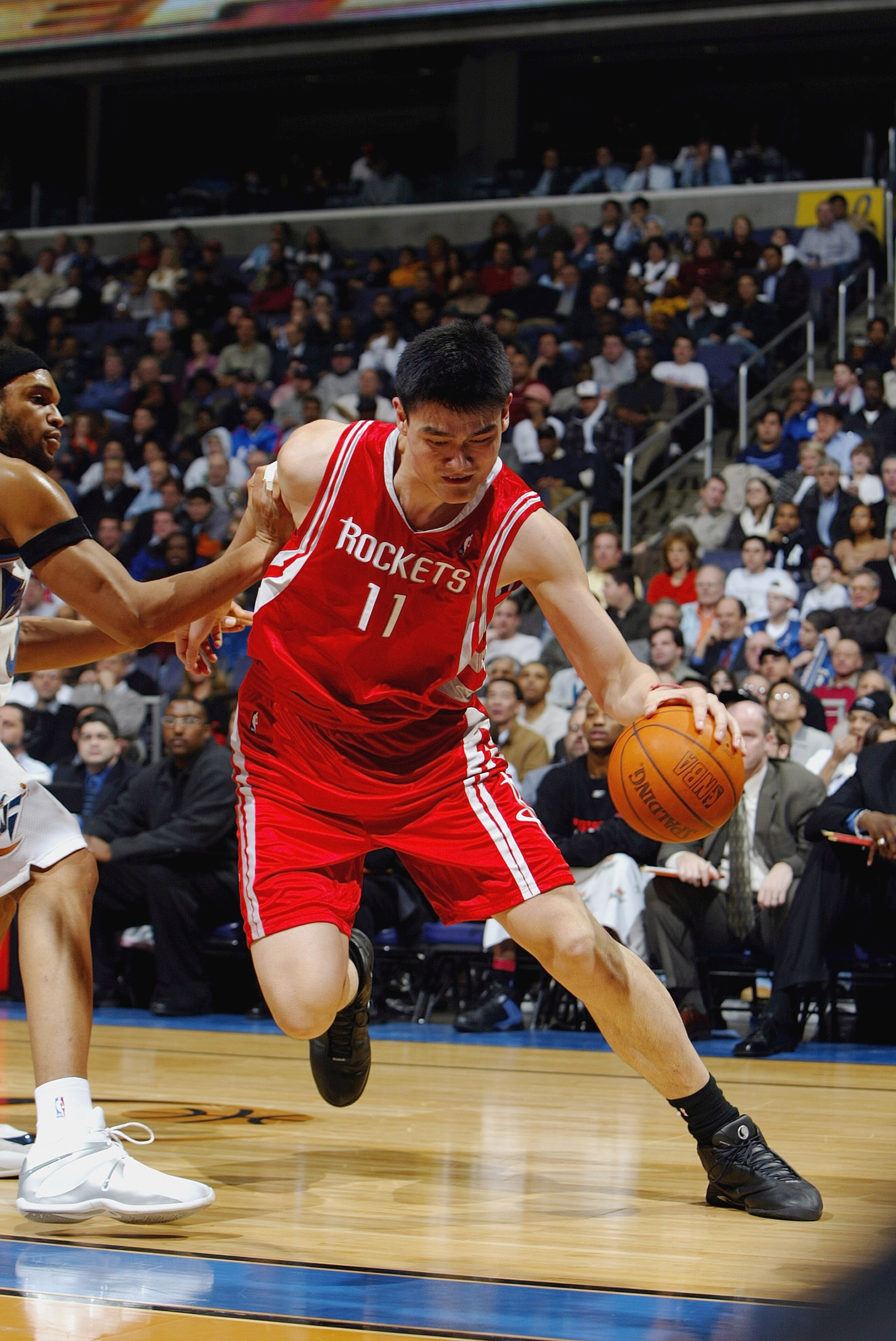 WASHINGTON - JANUARY 13:  Yao Ming #11 of the Houston Rockets drives around Etan Thomas #36 of the Washington Wizards during the game at MCI Center on January 13, 2004 in Washington, DC.  The Rockets won 93-80.  NOTE TO USER: User expressly acknowledges a