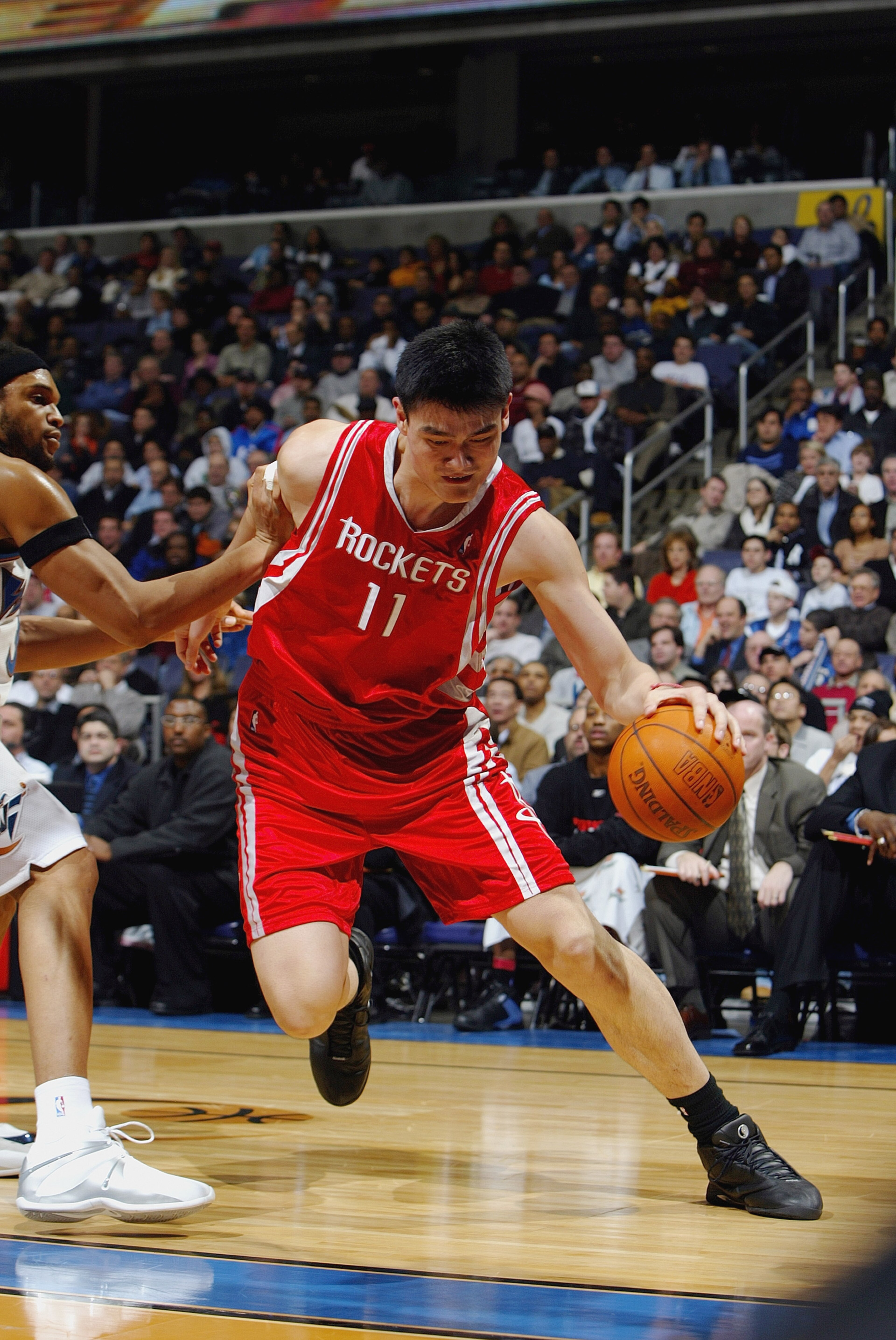 WASHINGTON - JANUARY 13:  Yao Ming #11 of the Houston Rockets drives around Etan Thomas #36 of the Washington Wizards during the game at MCI Center on January 13, 2004 in Washington, DC.  The Rockets won 93-80.  NOTE TO USER: User expressly acknowledges a