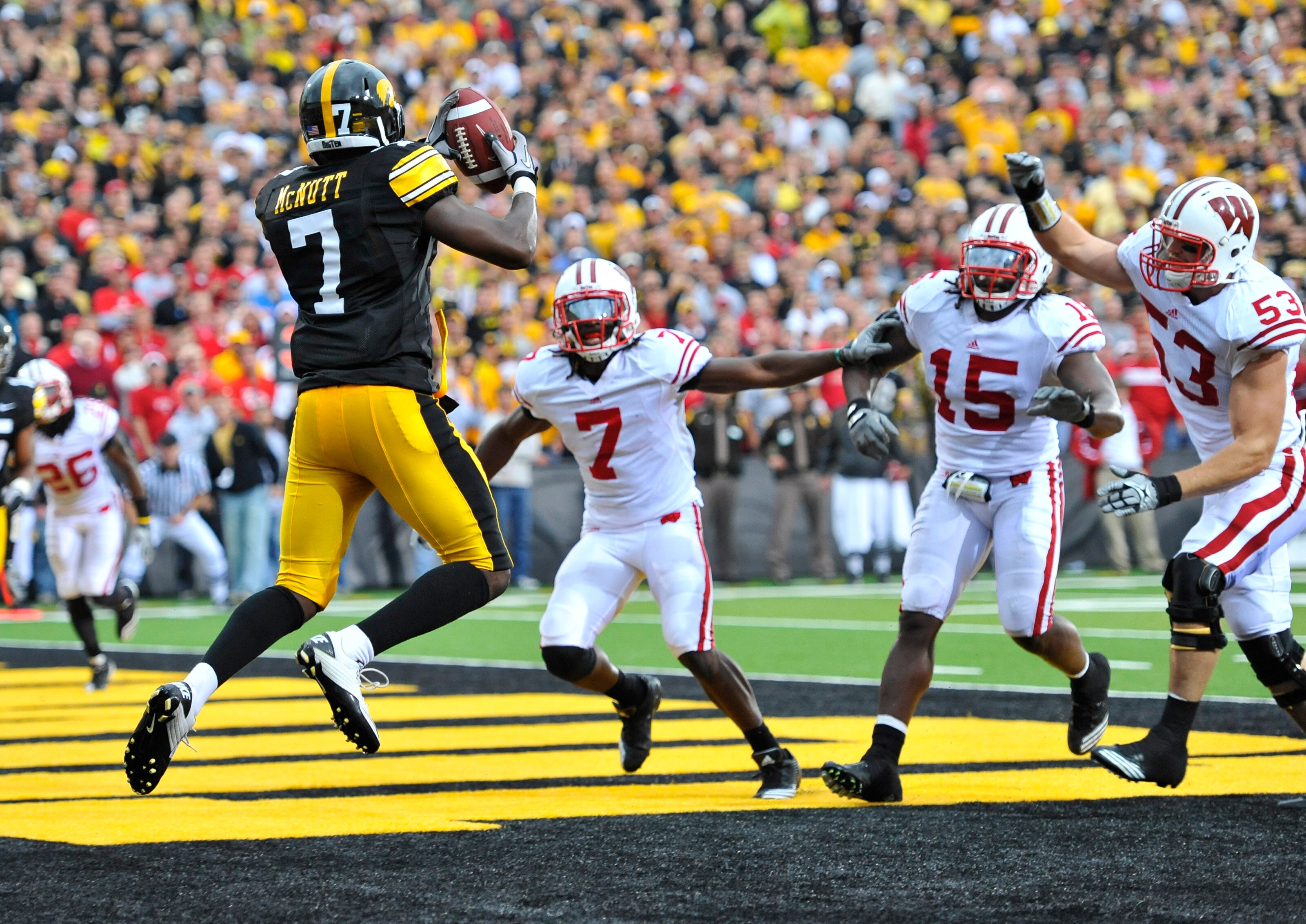 IOWA CITY, IA - OCTOBER 23: Wide receiver Marvin McNutt #7 of the  University of Iowa Hawkeyes catches a touchdown pass in the end zone as Aaron Henry #7, Culmer St. Jean #15, and Mike Taylor of the Wisconsin Badgers defend in the during the second half o
