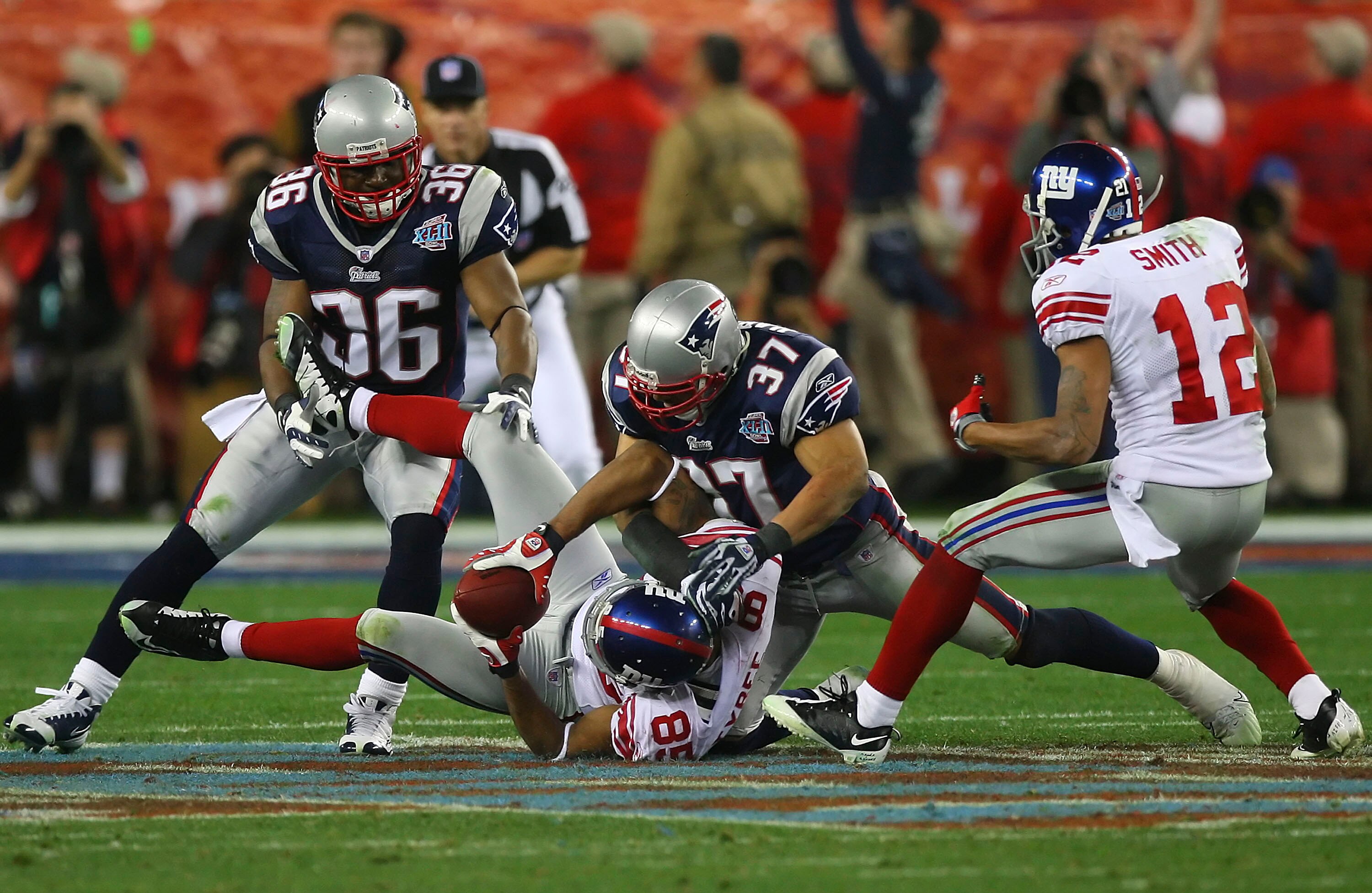 GLENDALE, AZ - FEBRUARY 03:  David Tyree #85 of the New York Giants catches a 32-yard pass from Eli Manning #10 as Rodney Harrison #37 of the New England Patriots comes down on him in the fourth quarter of Super Bowl XLII on February 3, 2008 at the Univer