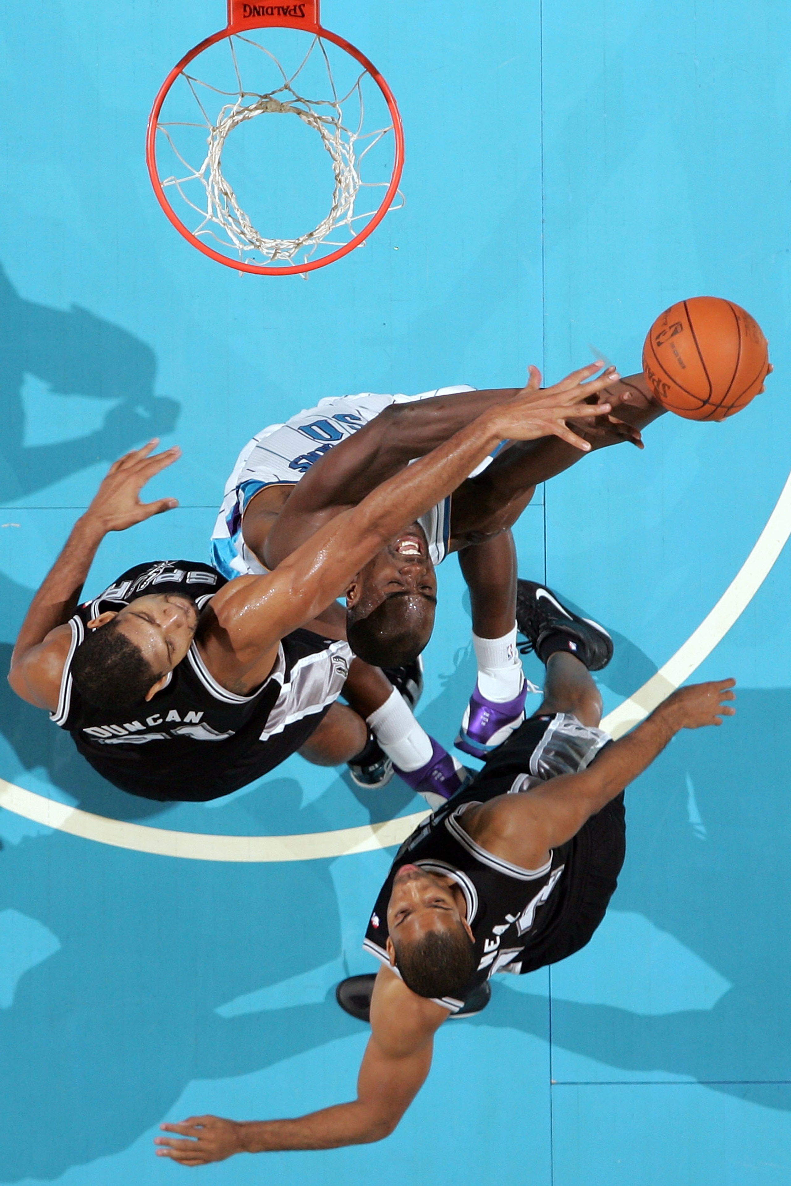 NEW ORLEANS - NOVEMBER 28:  Emeka Okafor #50 of the New Orleans Hornets shoots the ball over Tim Duncan #21 of the San Antonio Spurs at the New Orleans Arena on November 28, 2010 in New Orleans, Louisiana.  NOTE TO USER: User expressly acknowledges and ag