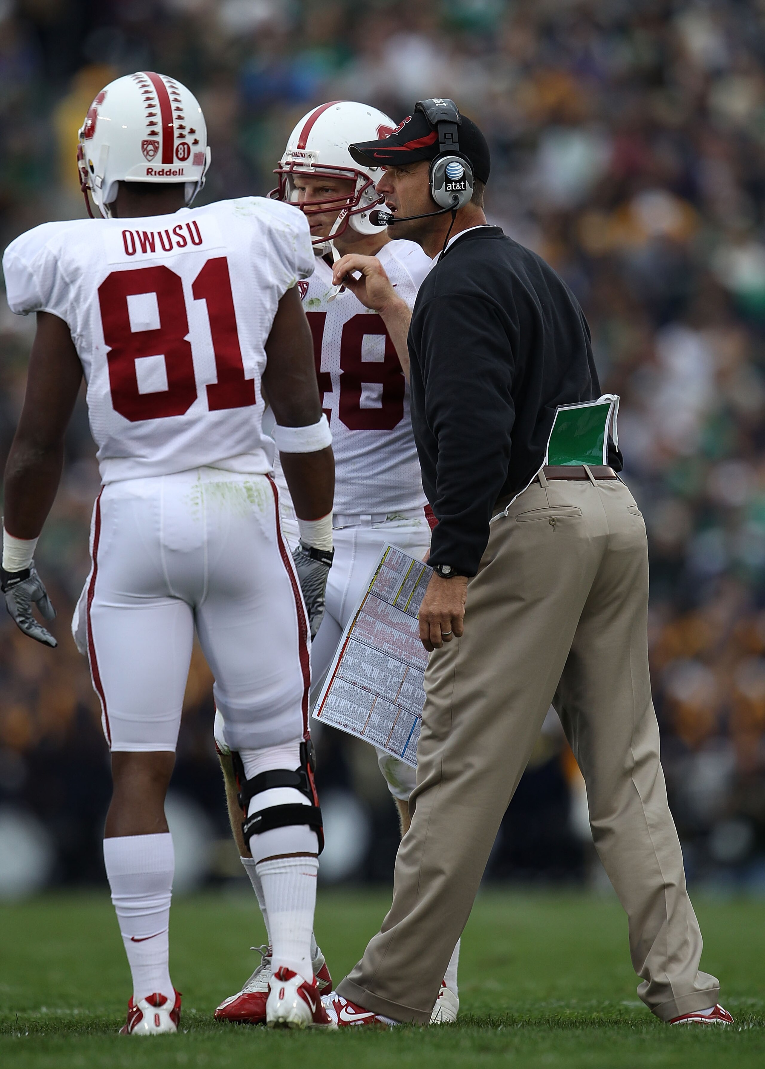 SOUTH BEND, IN - SEPTEMBER 25: Head coach Jim Harbaugh of the Stanford Cardinal gives instructions to Chris Owusu #81 and Owen Marecic #48 during a time out against the Notre Dame Fighting Irish at Notre Dame Stadium on September 25, 2010 in South Bend, I