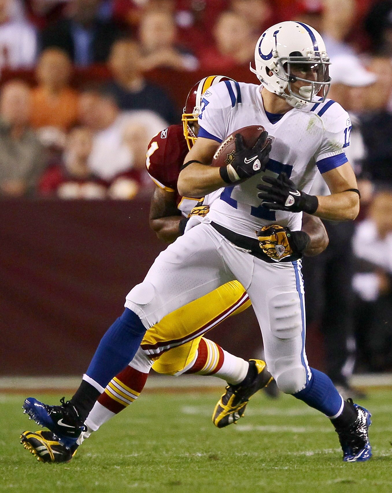 LANDOVER, MD - OCTOBER 17:  Austin Collie #17 of the Indianapolis Colts moves the ball upfield after making a reception against Kareem Moore #41 of the Washington Redskins at FedExField on October 17, 2010 in Landover, Maryland.  (Photo by Win McNamee/Get