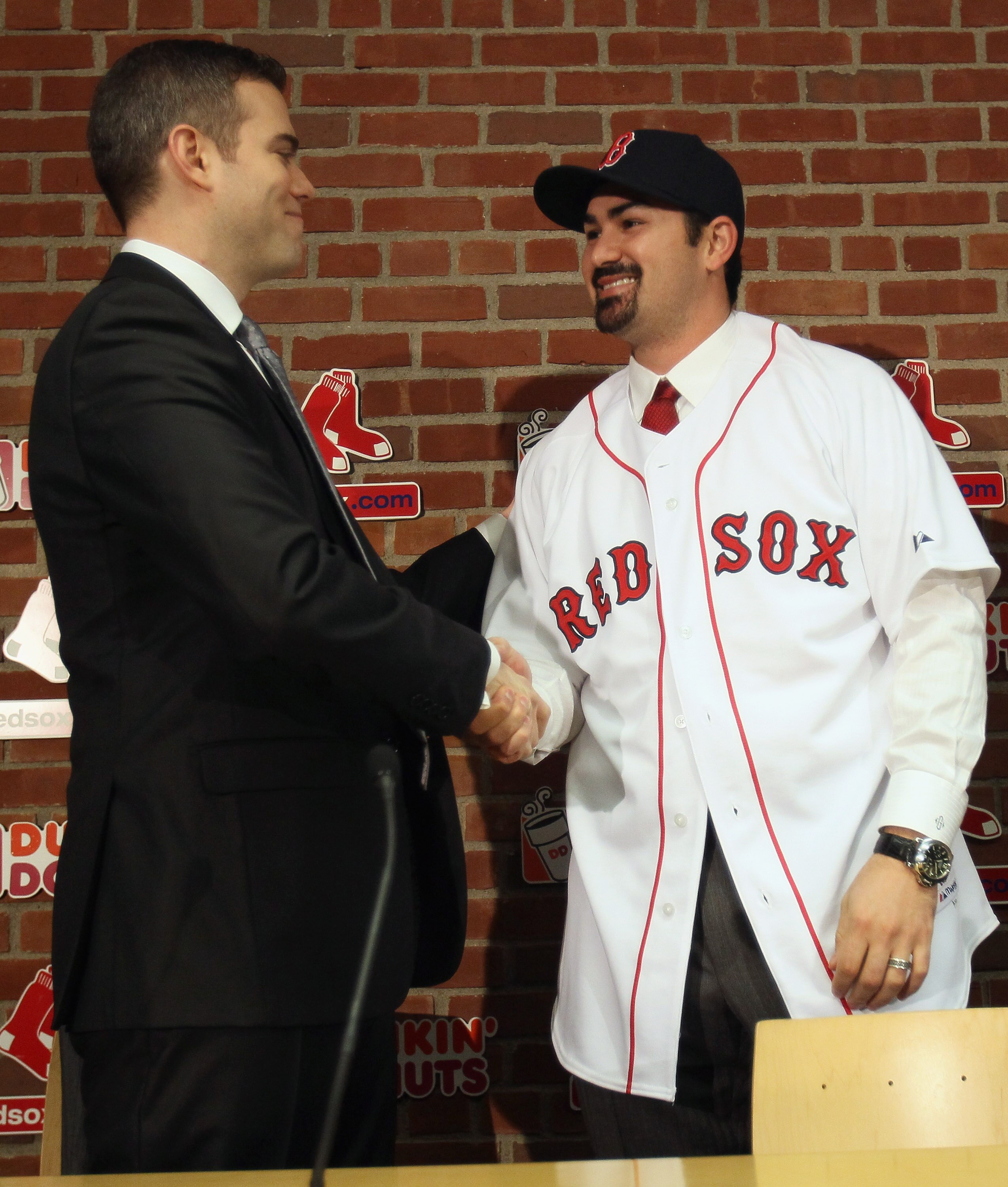 BOSTON, MA - DECEMBER 06:  Adrian Gonzalez (R) shakes hands with Boston Red Sox General Manager Theo Epstein after it was announced that Gonzalez signed with the Boston Red Sox on December 6,  2010 at Fenway Park in Boston, Massachusetts.  (Photo by Elsa/