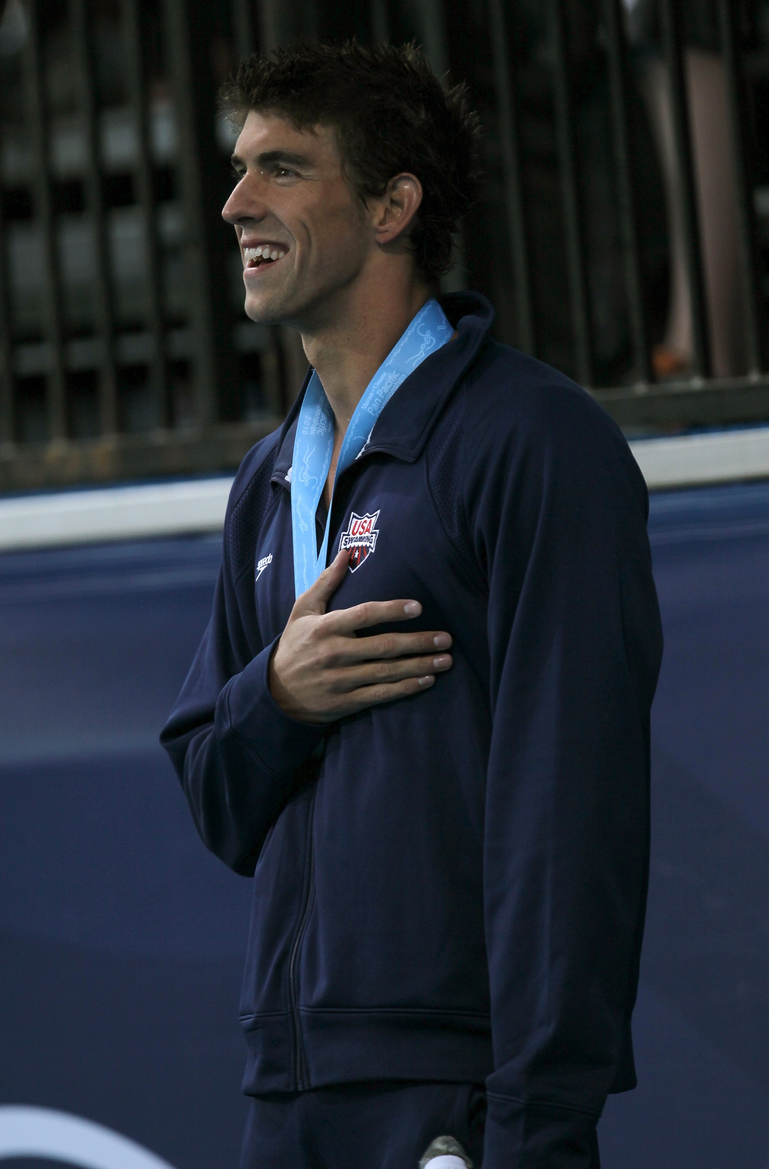 IRVINE, CA - AUGUST 20:  Michael Phelps stands during the national anthem during awards ceremonies after winning the men's 100m butterfly during the Mutual of Omaha Pan Pacific Championships at the William Woollett Jr. Aquatic Center on August 20, 2010 in