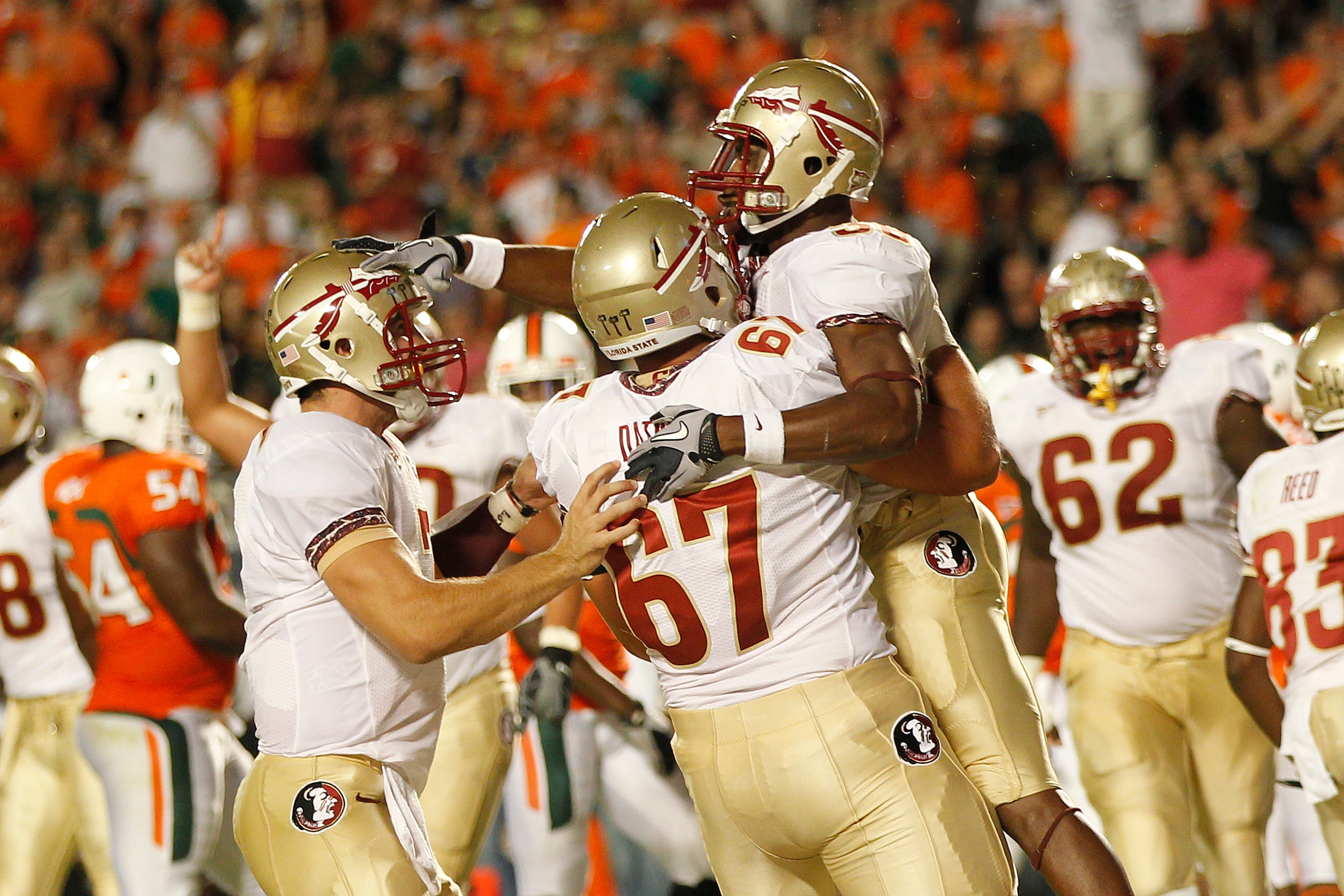 MIAMI, FL - OCTOBER 9: Jermaine Thomas #38 pats Christian Ponder #7 on the head as he is held by Andrew Datko #67 of the Florida State Seminoles after scoring a touchdown against the Miami Hurricanes on October 9, 2010 at Sun Life Stadium in Miami, Florid