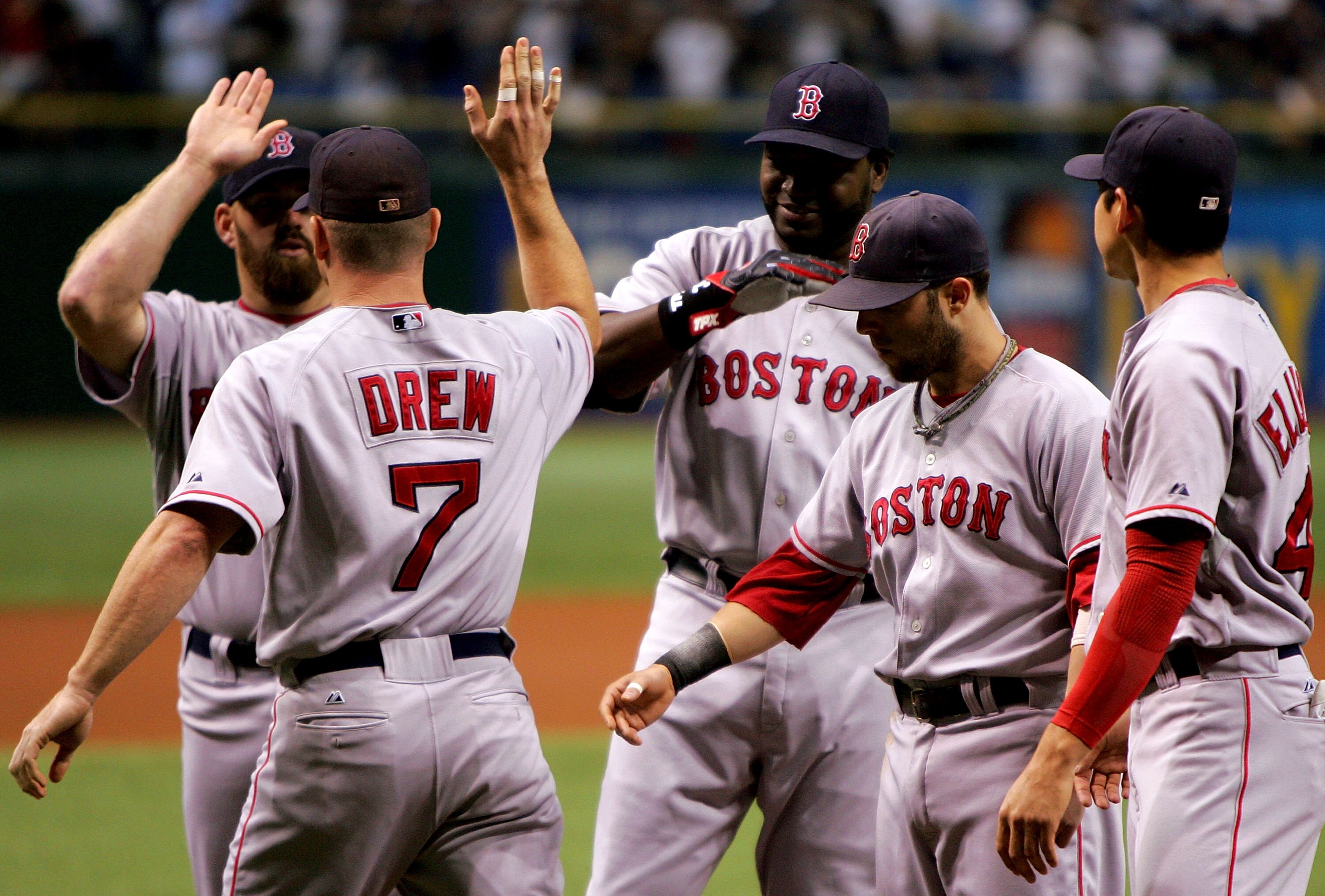 TAMPA, FL - OCTOBER 10:  J.D. Drew #7 of the Boston Red Sox high fives teammate Kevin Youkilis #20  in front of David Ortiz #34, Dustin Pedroia #15 and Jacoby Ellsbury #46 before they take on the Tampa Bay Devil Rays in game one of the American League Cha