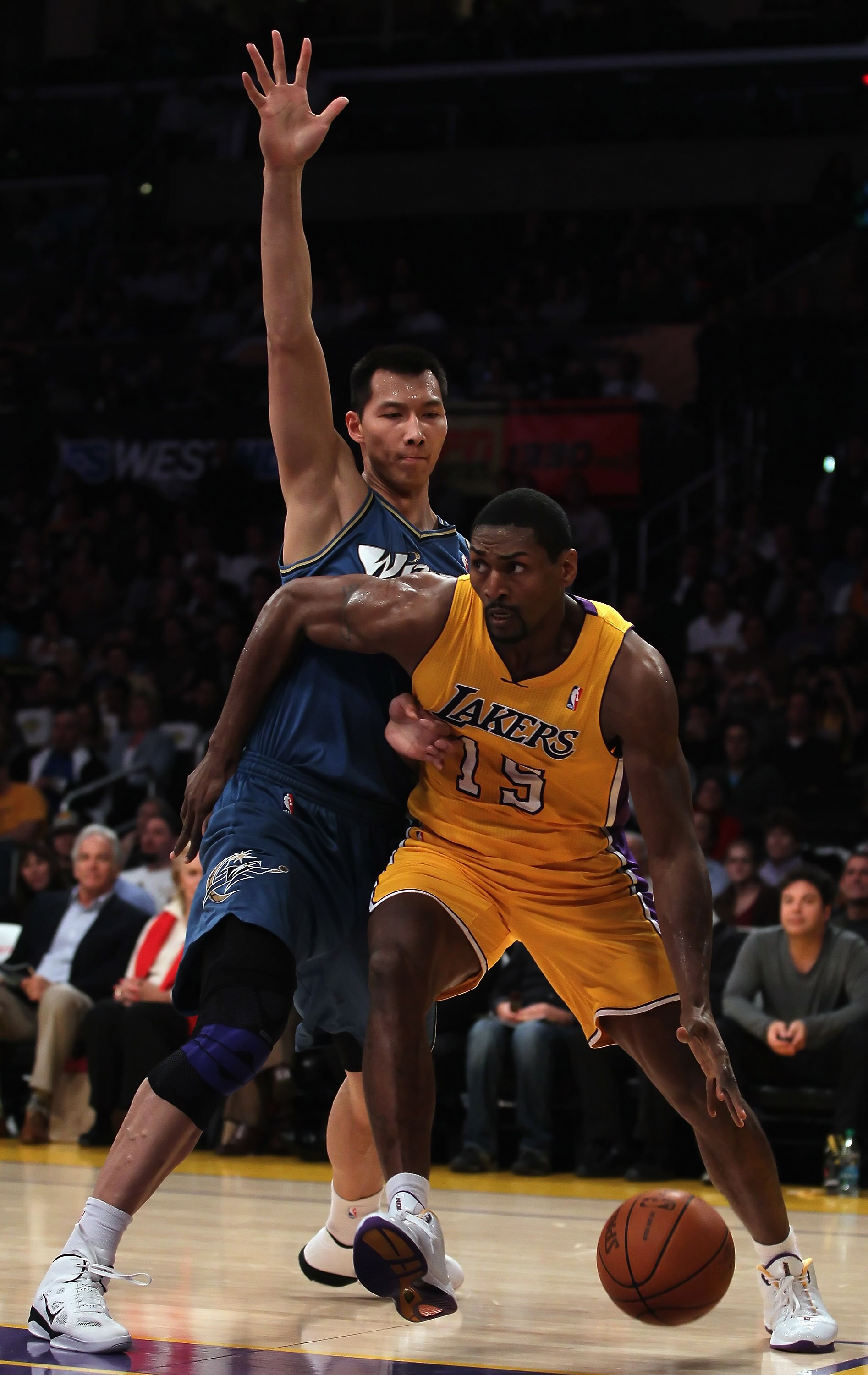 LOS ANGELES, CA - DECEMBER 07:  Ron Artest #15 of the Los Angeles Lakers drives to the basket past Yi Jianlian #31 of the Washington Wizards in the first half at Staples Center on December 7, 2010 in Los Angeles, California. NOTE TO USER: User expressly a