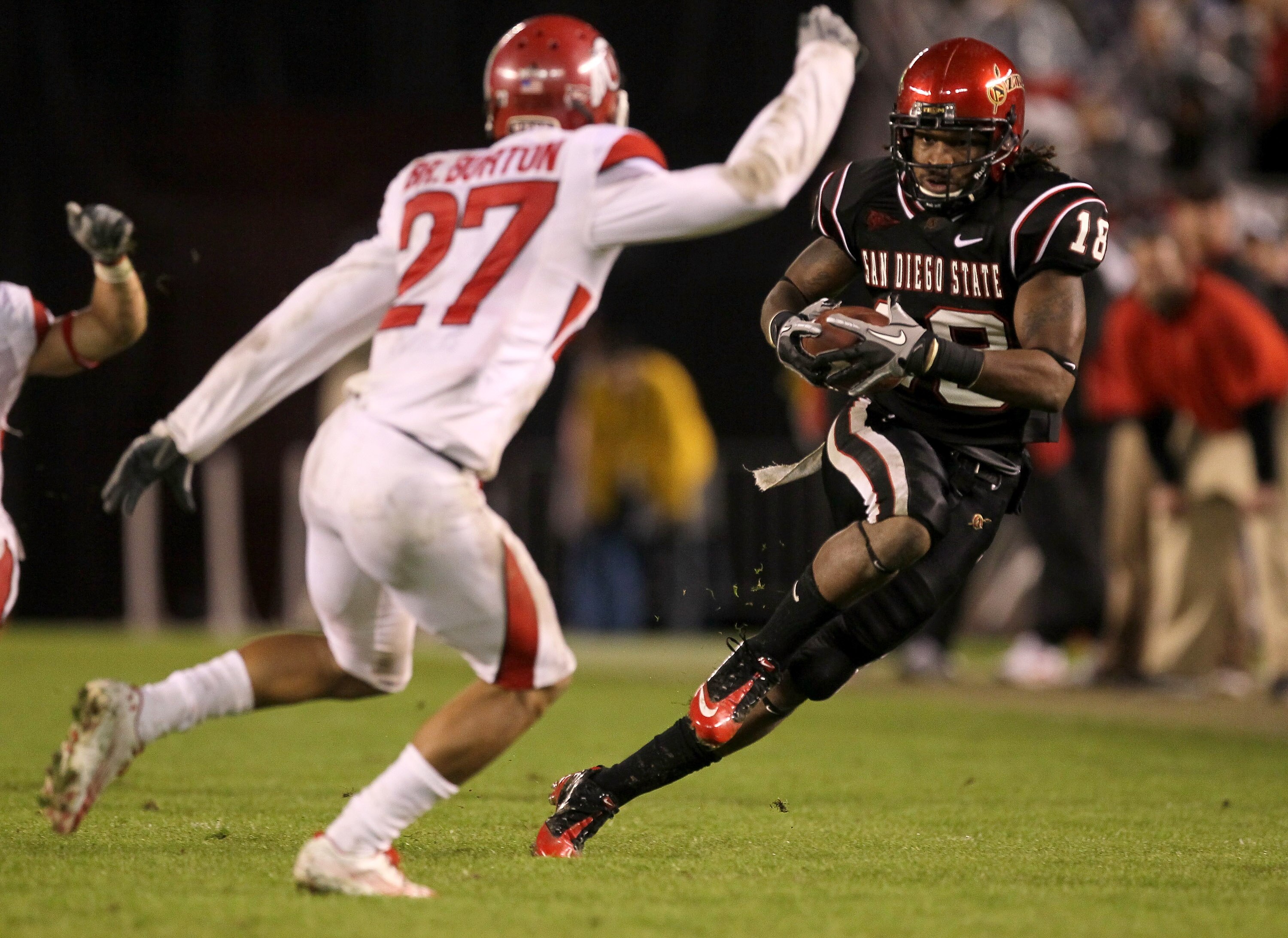 SAN DIEGO - NOVEMBER 20:  Wide receiver Dominique Sandifer #18 of the San Diego State Aztecs carries the ball against cornerback Brandon Burton #27 of the Utah Utes at Qualcomm Stadium on November 20, 2010 in San Diego, California.  Utah won 38-34.  (Phot