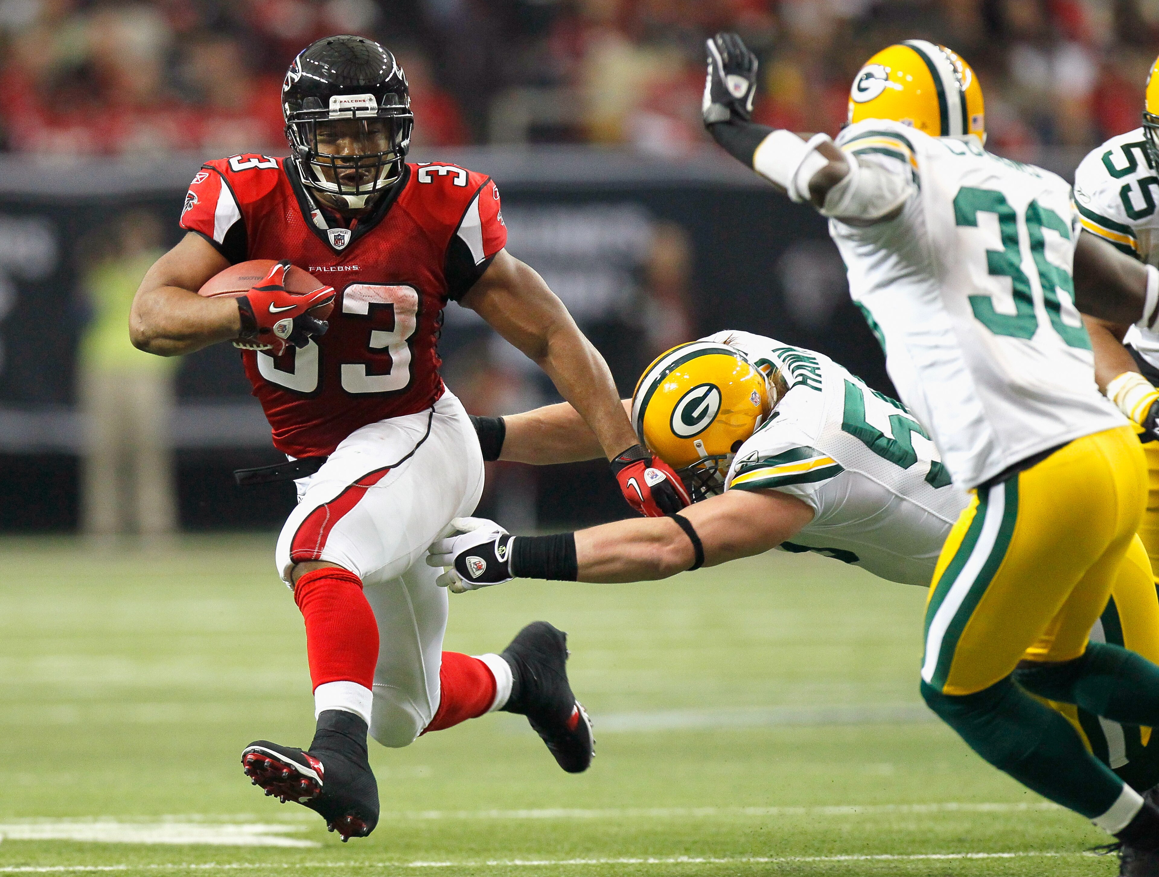 ATLANTA - NOVEMBER 28:  Michael Turner #33 of the Atlanta Falcons rushes rushes upfield away from A.J. Hawk #50 and Nick Collins #36 of the Green Bay Packers at Georgia Dome on November 28, 2010 in Atlanta, Georgia.  (Photo by Kevin C. Cox/Getty Images)