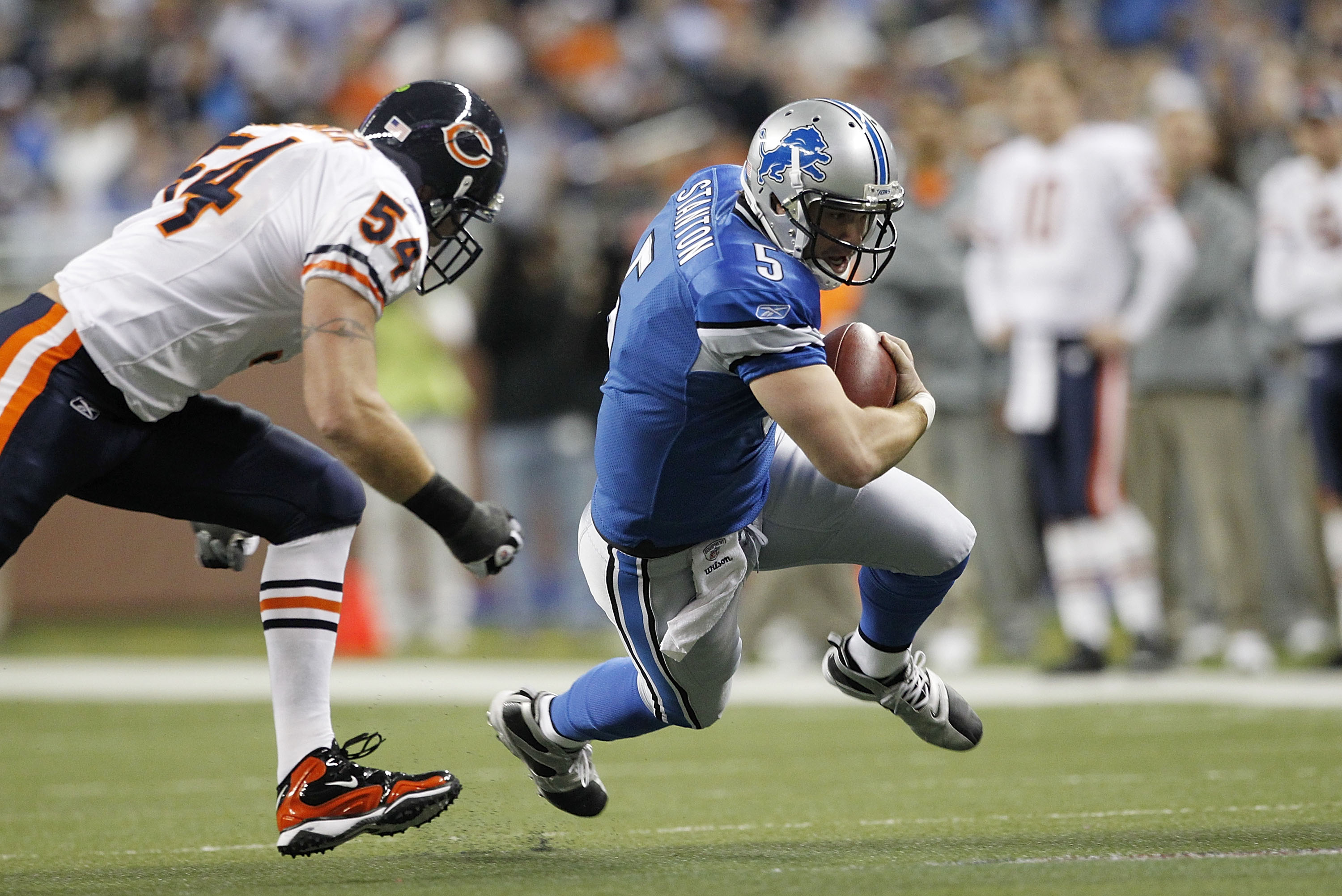 DETROIT - DECEMBER 05: Drew Stanton #5 of the Detroit Lions runs for a first down during the first quarter as Brian Urlacher #54 of the Chicago Bears give chase during the game at Ford Field on December 5, 2010 in Detroit, Michigan.  (Photo by Leon Halip/