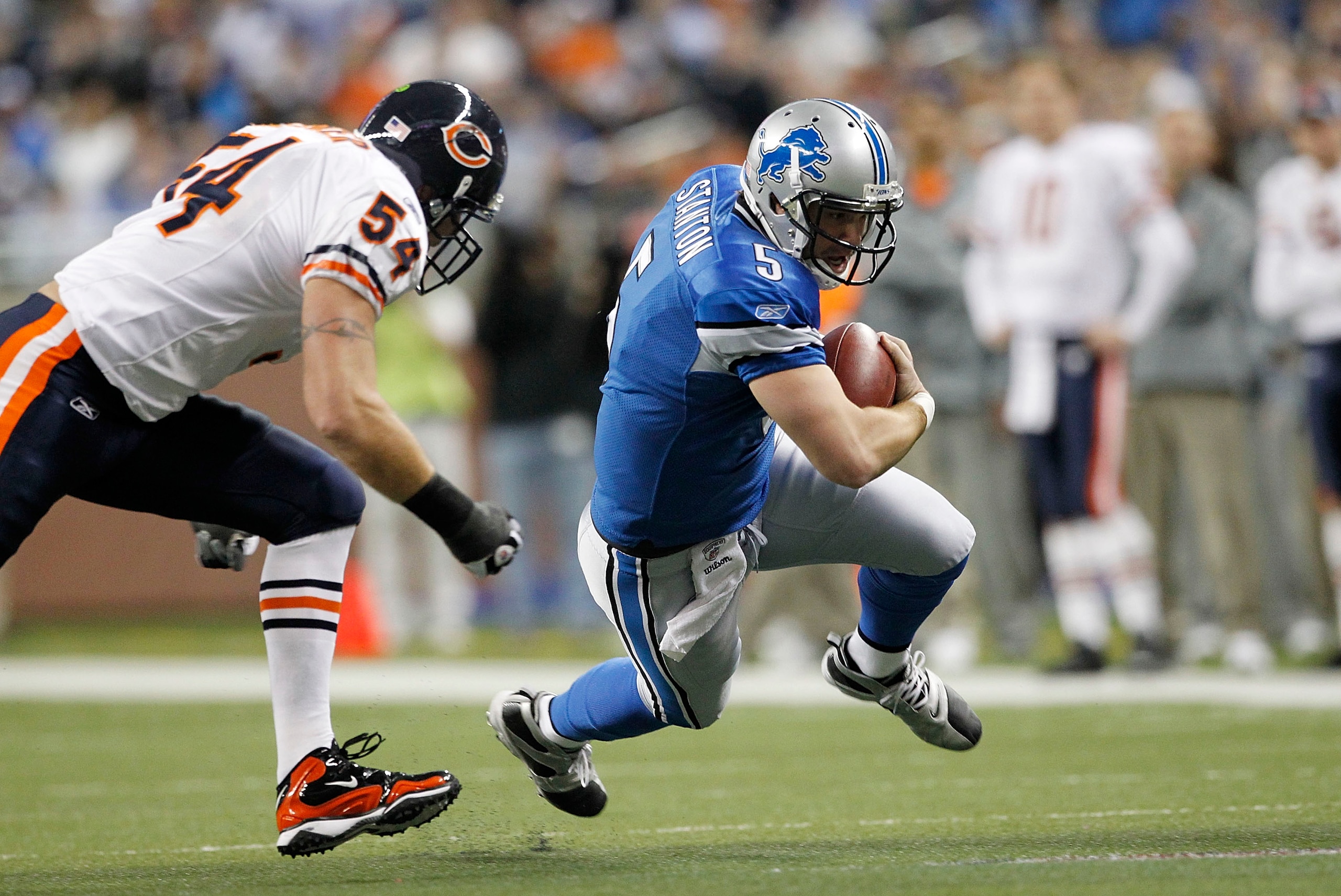 DETROIT - DECEMBER 05: Drew Stanton #5 of the Detroit Lions runs for a first down during the first quarter as Brian Urlacher #54 of the Chicago Bears give chase during the game at Ford Field on December 5, 2010 in Detroit, Michigan.  (Photo by Leon Halip/