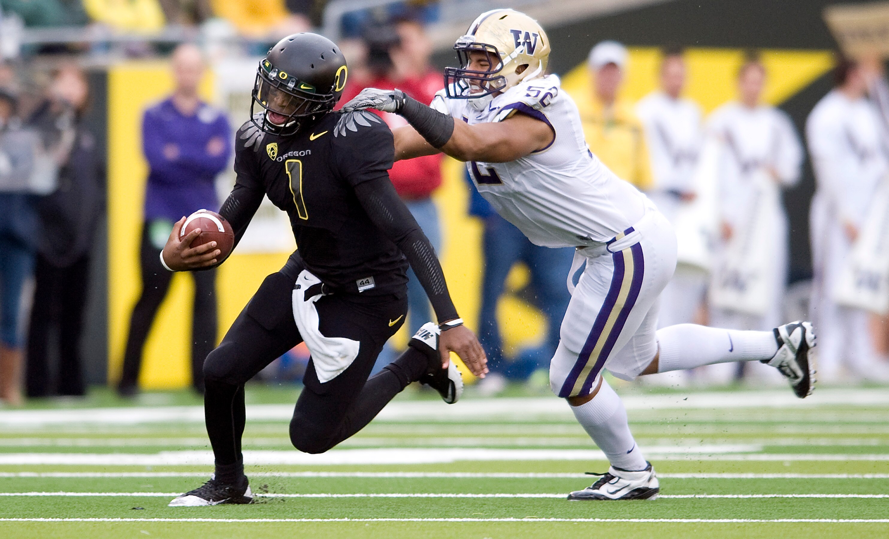 EUGENE, OR - NOVEMBER 06: Defensive end Hau'oli Jamora #52 of the Washington Huskies tries to tackle quarterback Darron Thomas #1 of the Oregon Ducks in the third quarter of the game at Autzen Stadium on November 6, 2010 in Eugene, Oregon. The Ducks won t