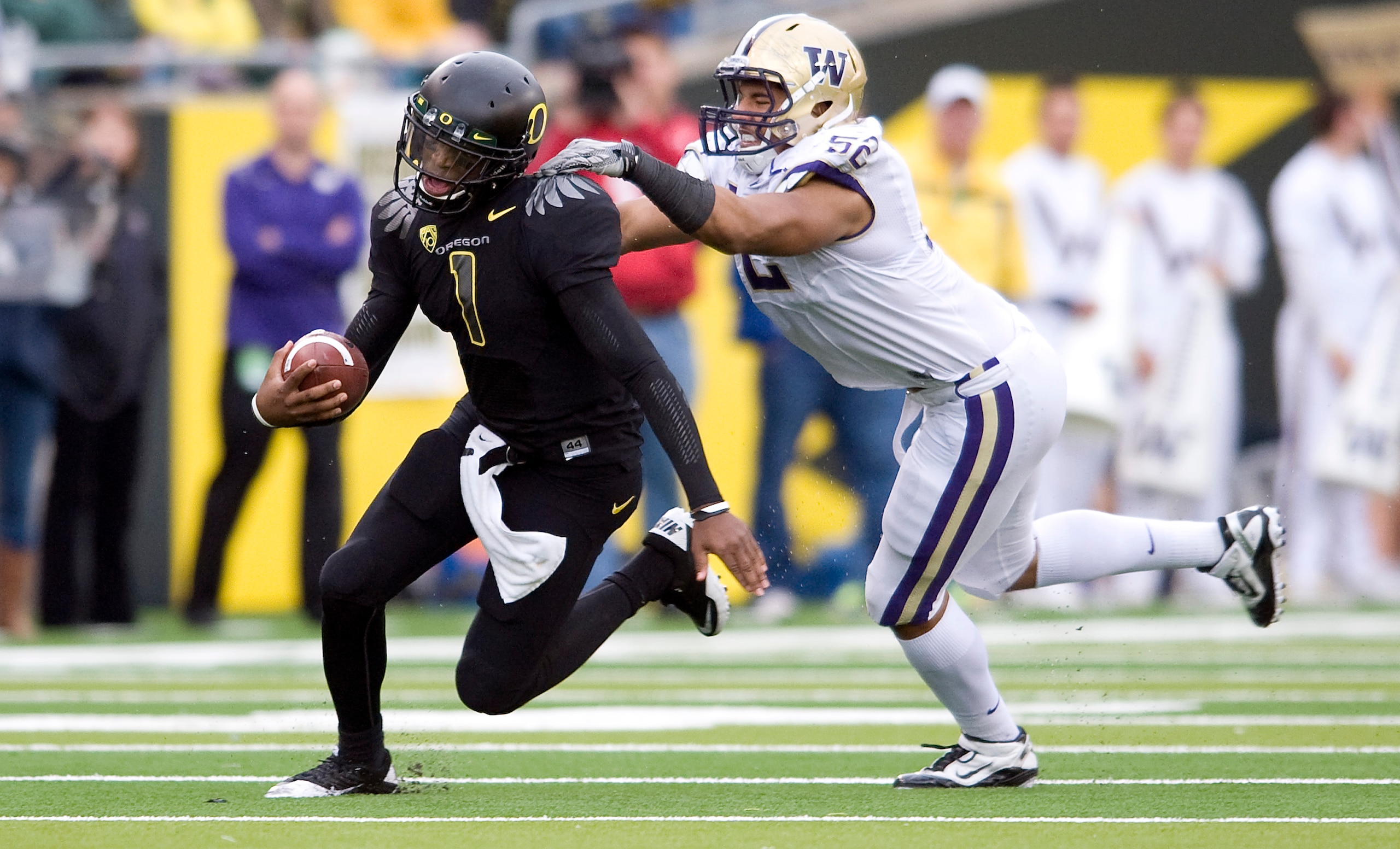 EUGENE, OR - NOVEMBER 06: Defensive end Hau'oli Jamora #52 of the Washington Huskies tries to tackle quarterback Darron Thomas #1 of the Oregon Ducks in the third quarter of the game at Autzen Stadium on November 6, 2010 in Eugene, Oregon. The Ducks won t