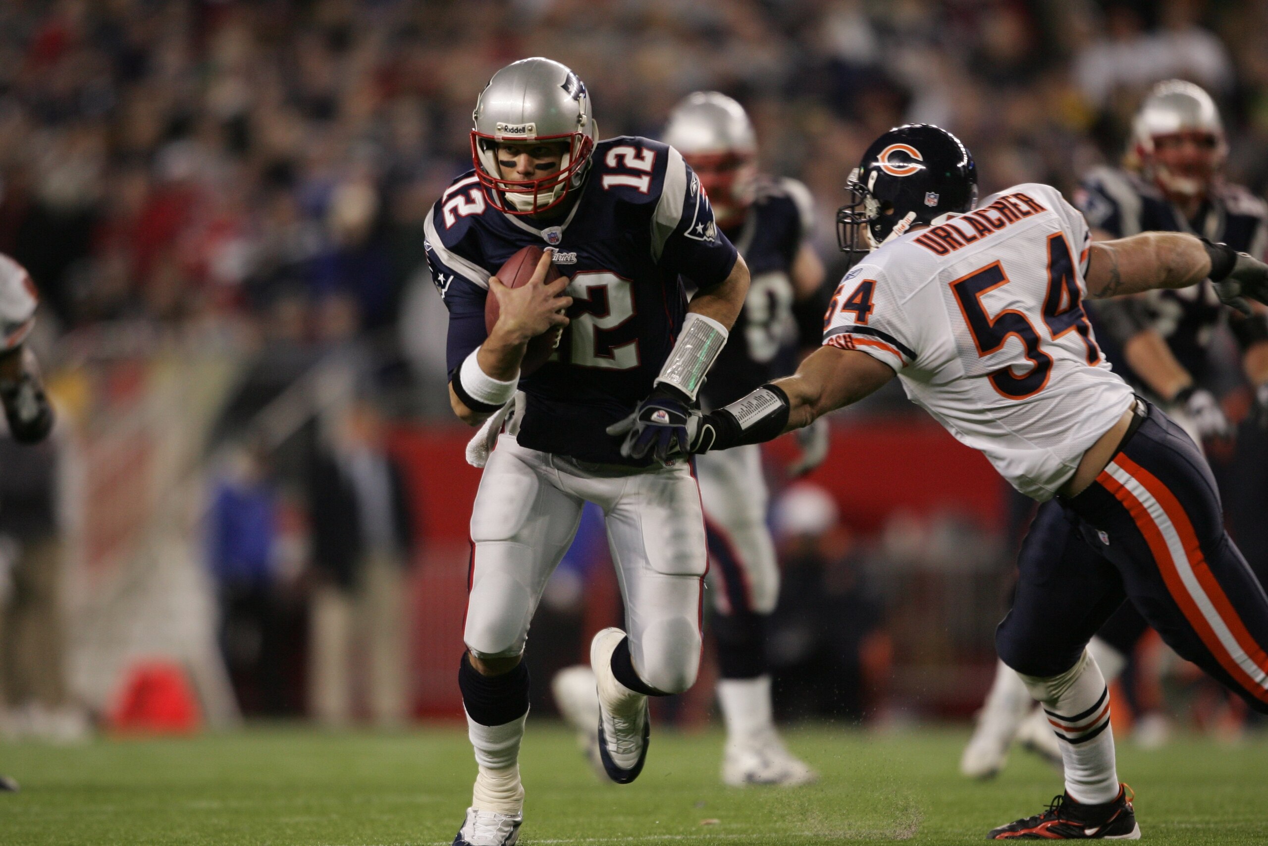 FOXBOROUGH, MA - NOVEMBER 26:  Quarterback Tom Brady #12 of the New England Patriots runs with the ball against linebacker Brian Urlacher #54 of the Chicago Bears on November 26, 2006 at Gillette Stadium in Foxborough, Massachusetts. The Patriots defeated