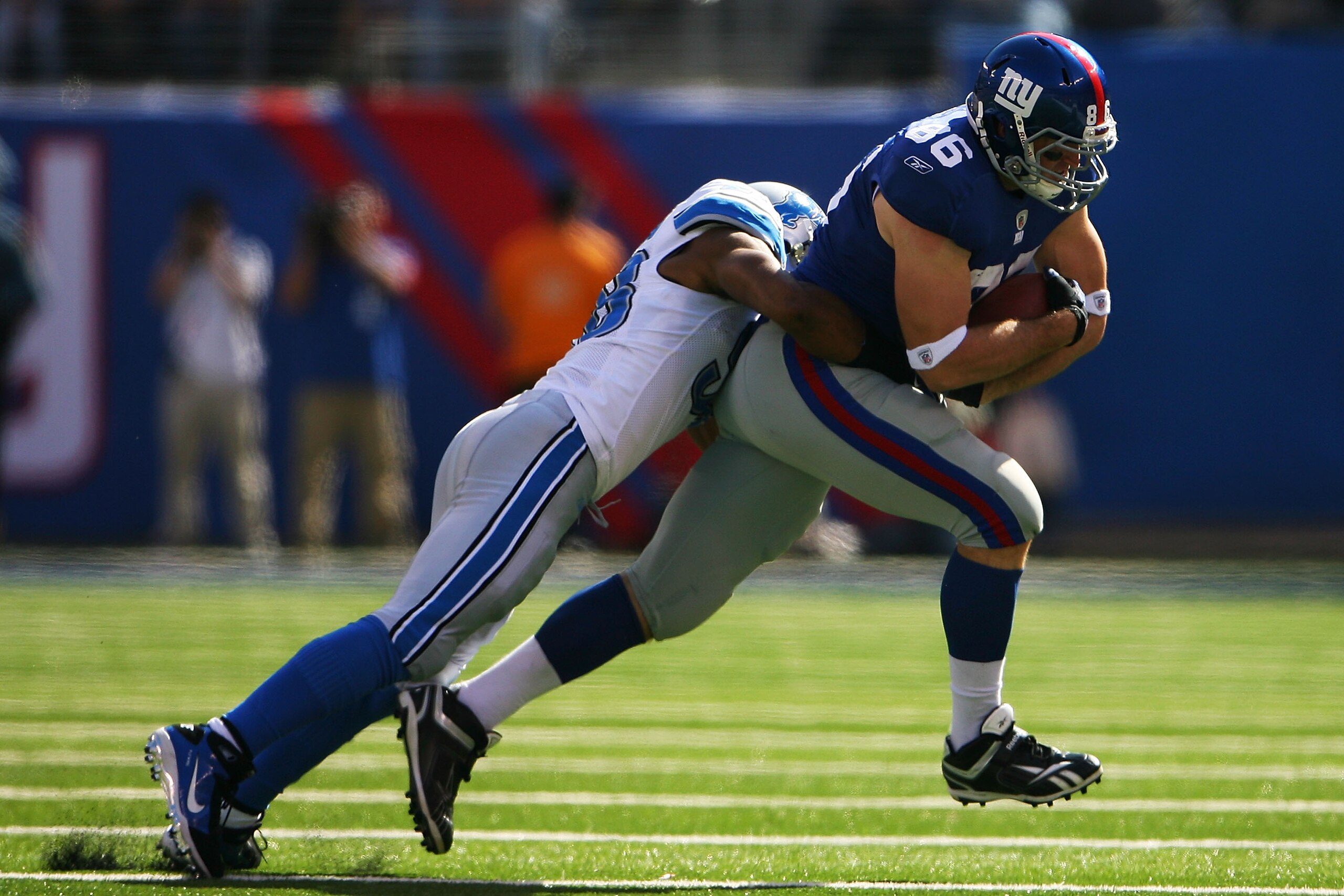 EAST RUTHERFORD, NJ - OCTOBER 17:  Bear Pascoe #86 of the New York Giants is tackled by Julian Peterson #98 of the Detroit Lions at New Meadowlands Stadium on October 17, 2010 in East Rutherford, New Jersey.  (Photo by Andrew Burton/Getty Images)