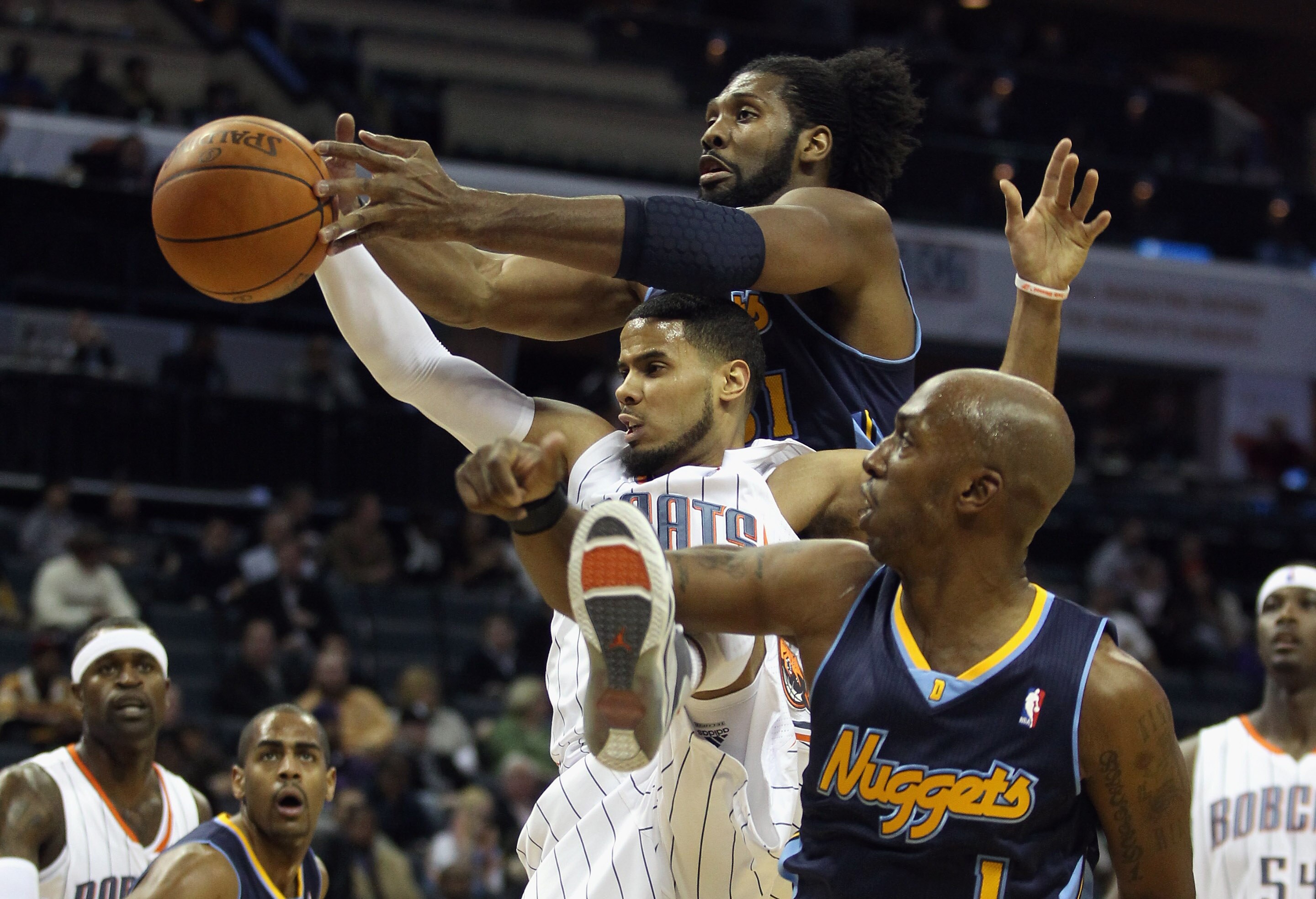 CHARLOTTE, NC - DECEMBER 07:  Teammates Nene #31 and Chauncey Billups #1 of the Denver Nuggets try to stop D.J. Augustin #14 of the Charlotte Bobcats during their game at Time Warner Cable Arena on December 7, 2010 in Charlotte, North Carolina.  NOTE TO U