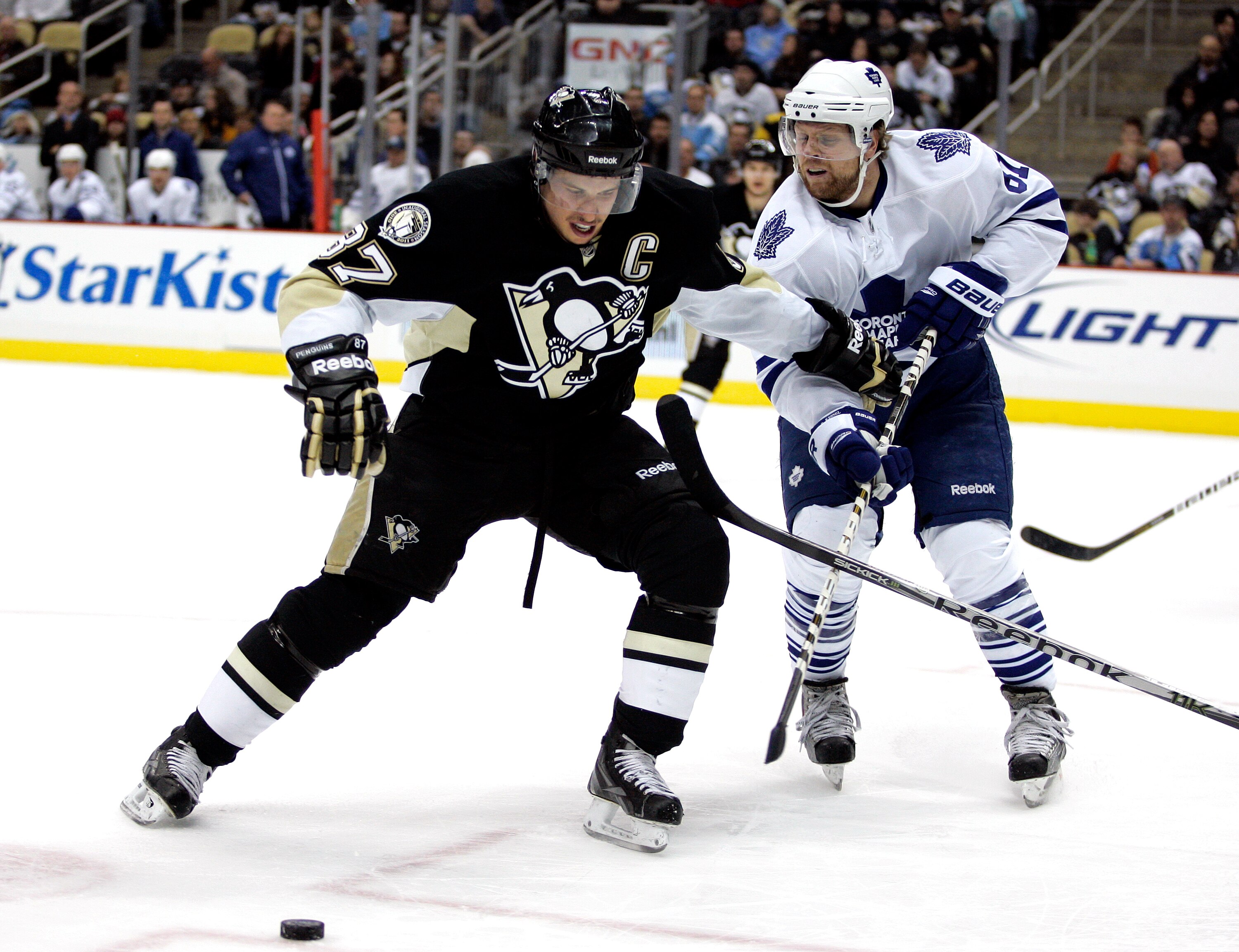 PITTSBURGH, PA - DECEMBER 08:  Sidney Crosby #87 of the Pittsburgh Penguins handles the puck in his feet against Phil Kessel #81 of the Toronto Maple Leafs at Consol Energy Center on December 8, 2010 in Pittsburgh, Pennsylvania.  (Photo by Justin K. Aller