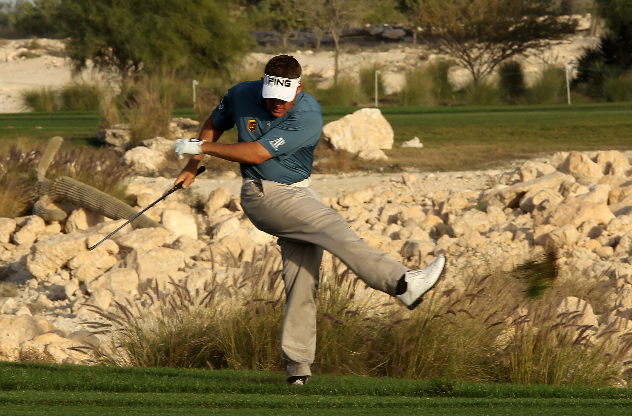 DOHA, QATAR - JANUARY 30:  Lee Westwood of England shows his frustration by kicking up a clump of grass after his second shot on the 18th hole during the third round of the Commercialbank Qatar Masters at Doha Golf Club on January 30, 2010 in Doha, Qatar.