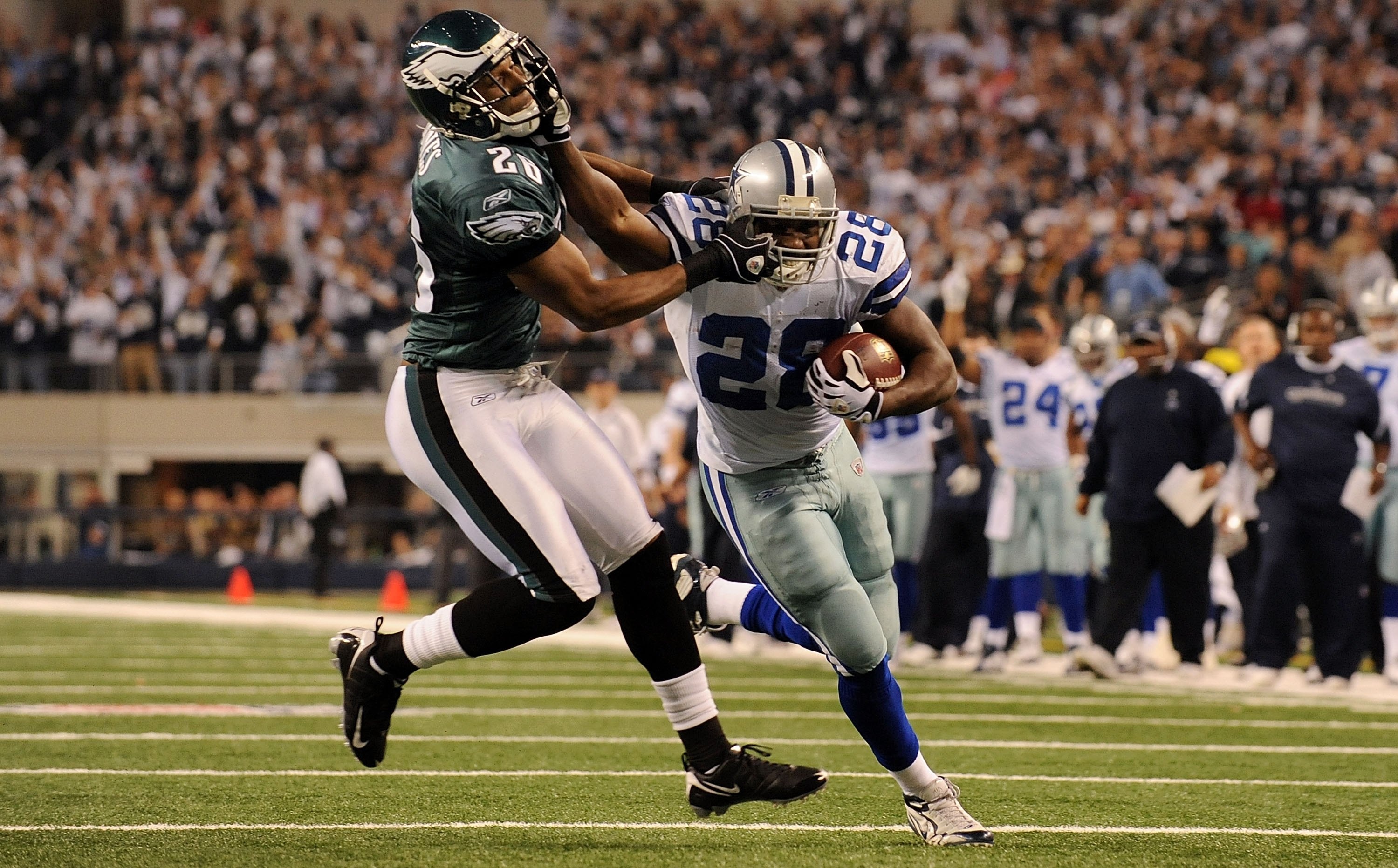ARLINGTON, TX - JANUARY 09:  Running back Felix Jones #28 of the Dallas Cowboys runs the ball past Sean Jones #26 of the Philadelphia Eagles during the 2010 NFC wild-card playoff game at Cowboys Stadium on January 9, 2010 in Arlington, Texas.  (Photo by R