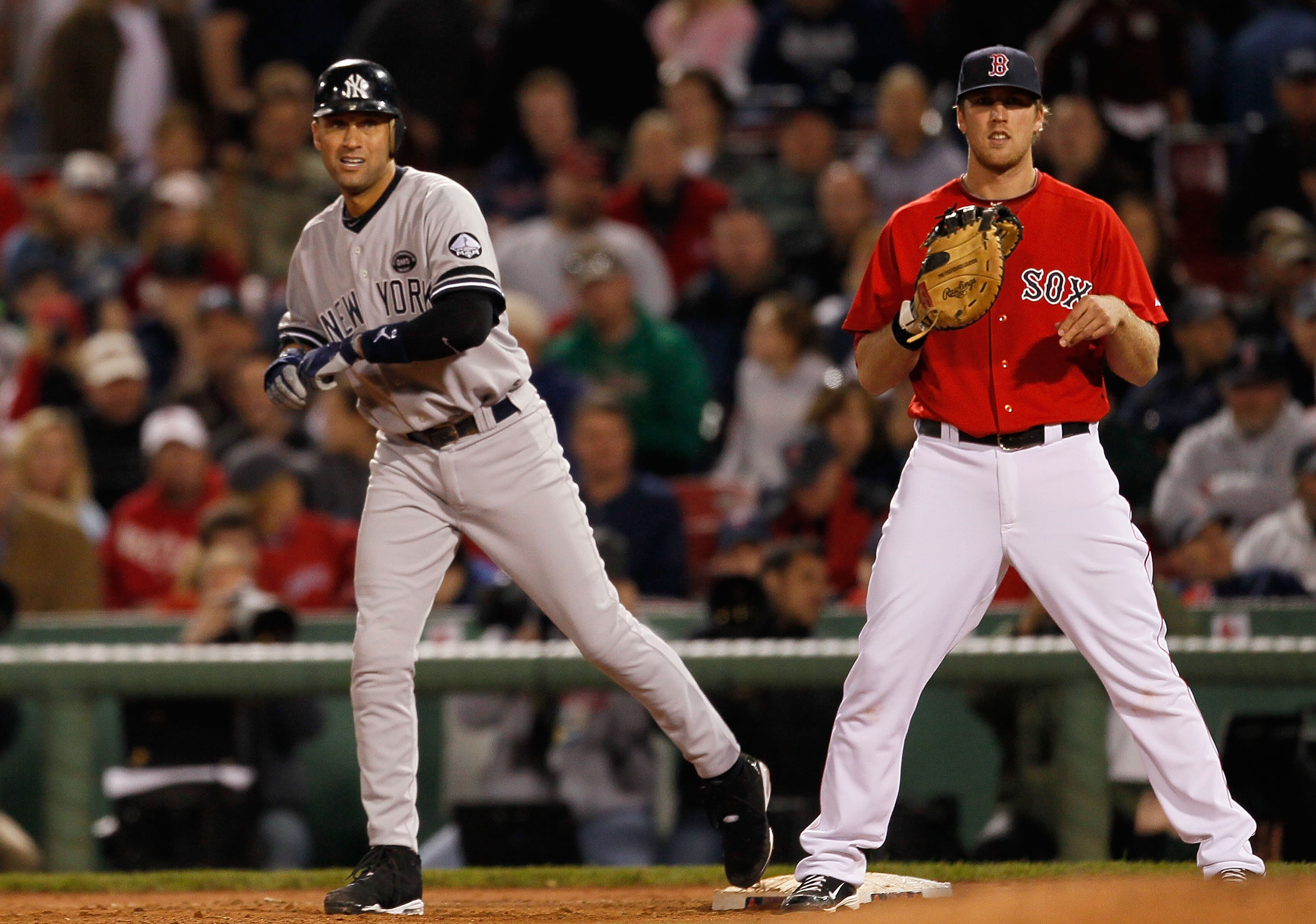 BOSTON - OCTOBER 2:  Derek Jeter #2 of the New York Yankees reaches first on an infield hit as Lars Anderson of the Boston Red Sox looks on during the first game of a doubleheader at Fenway Park October 2, 2010 in Boston, Massachusetts. The Yankees won 6-