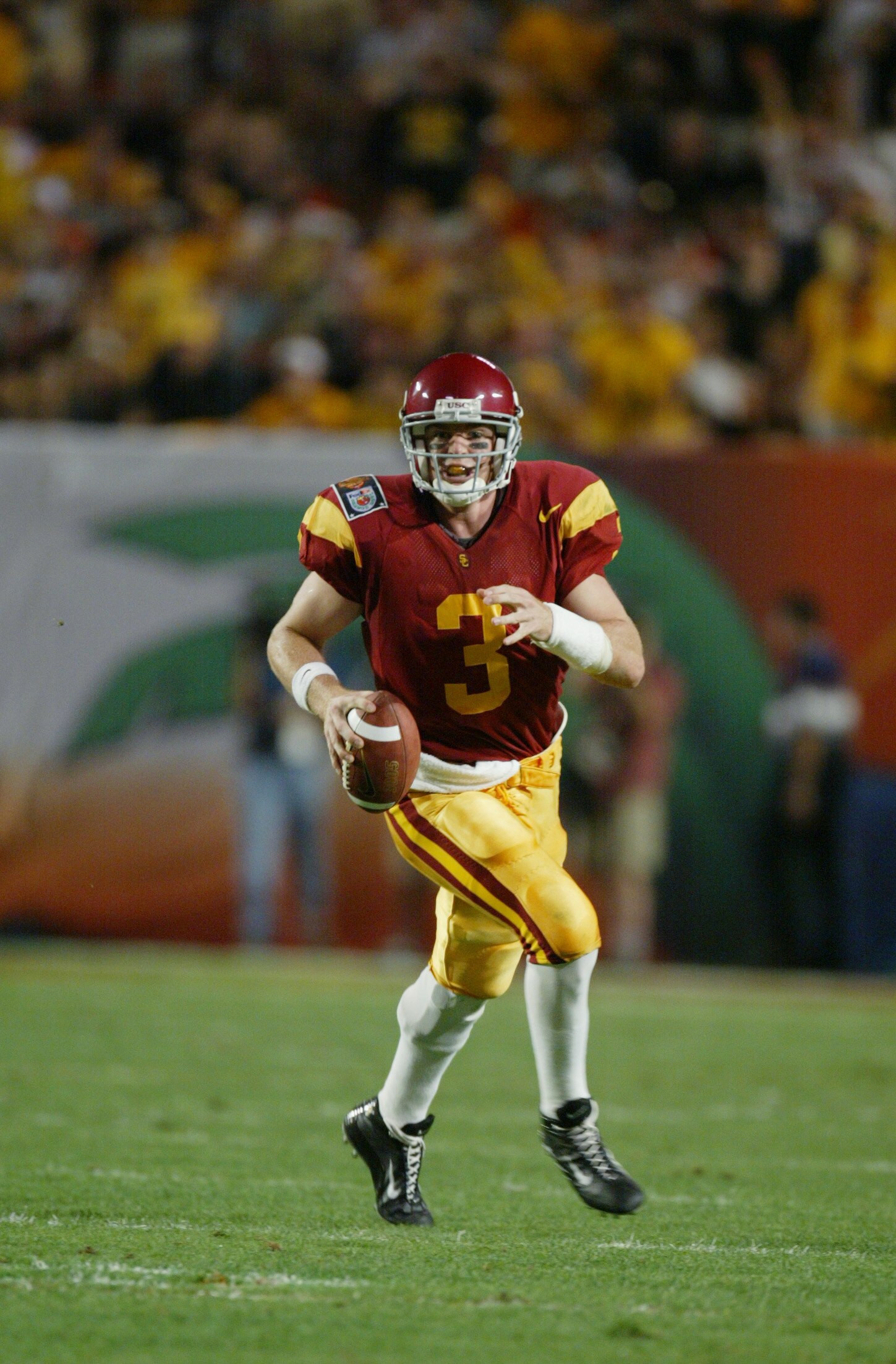 MIAMI - JANUARY 2:  Carson Palmer #3 of USC runs with the ball against Iowa during the FedEx Orange Bowl on January 2, 2003 at Pro Player Stadium in Miami, Florida.  USC defeated Iowa 38-17.  (Photo by Eliot J. Schechter/Getty Images)