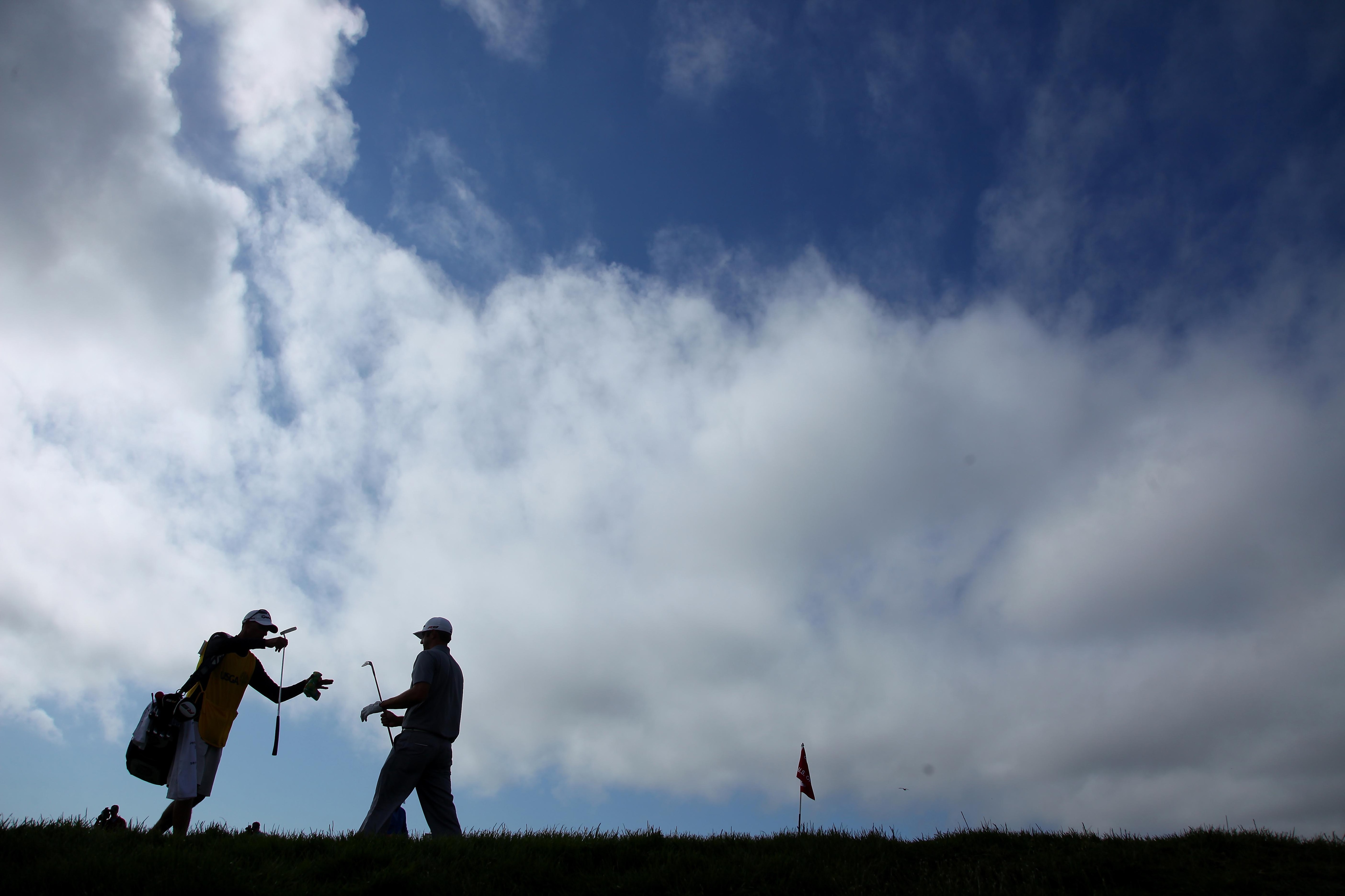 PEBBLE BEACH, CA - JUNE 19:  Dustin Johnson grabs his putter from his caddie Bobby Brown on the eigth hole during the third round of the 110th U.S. Open at Pebble Beach Golf Links on June 19, 2010 in Pebble Beach, California.  (Photo by Donald Miralle/Get