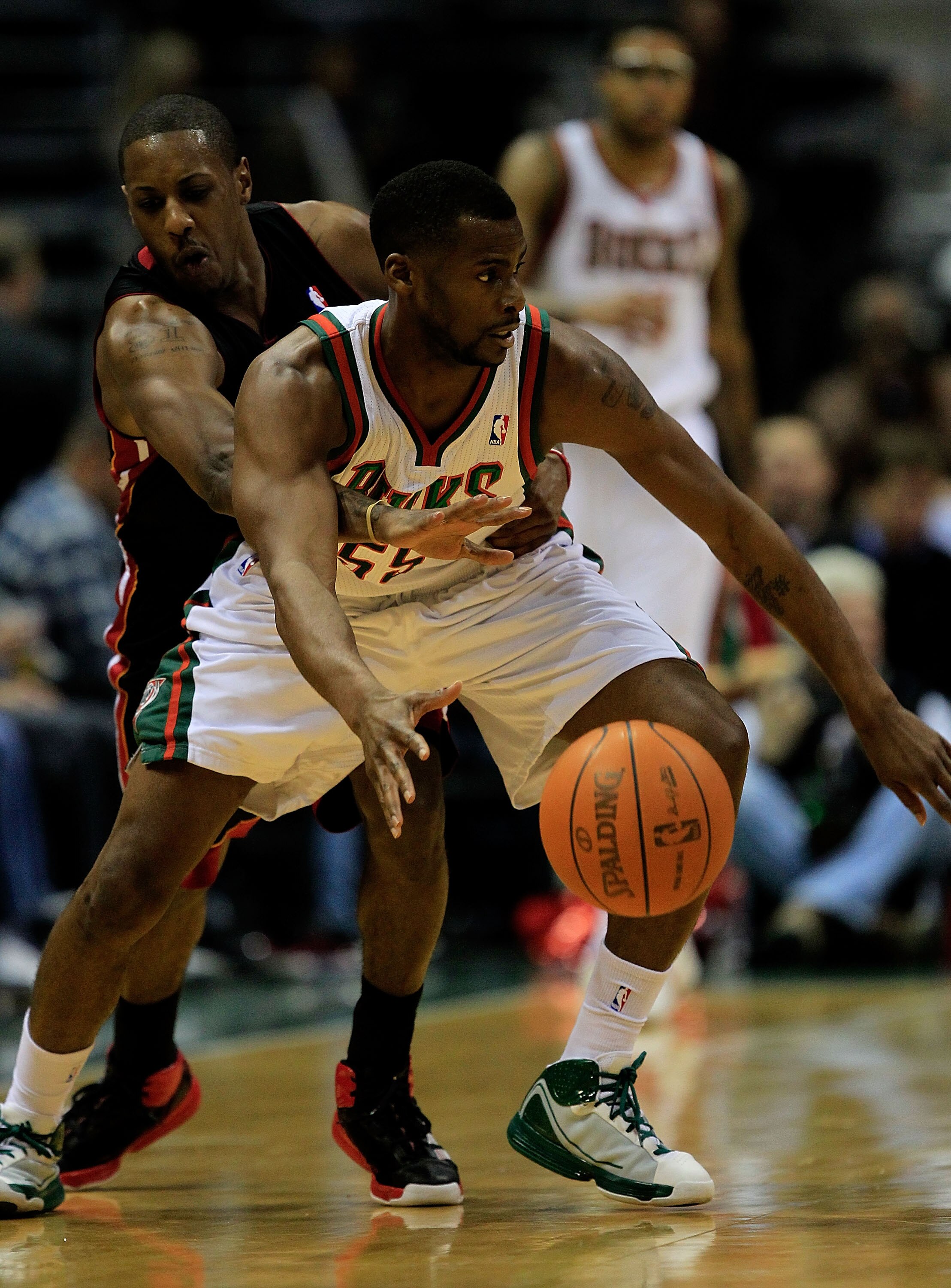 MILWAUKEE, WI - DECEMBER 06: Mario Chalmers #15 of the Miami Heat tries to knock the ball away from Keyon Dooling #55 of the Milwaukee Bucks at the Bradley Center on December 6, 2010 in Milwaukee, Wisconsin. The Heat defeated the Bucks 88-78. NOTE TO USER