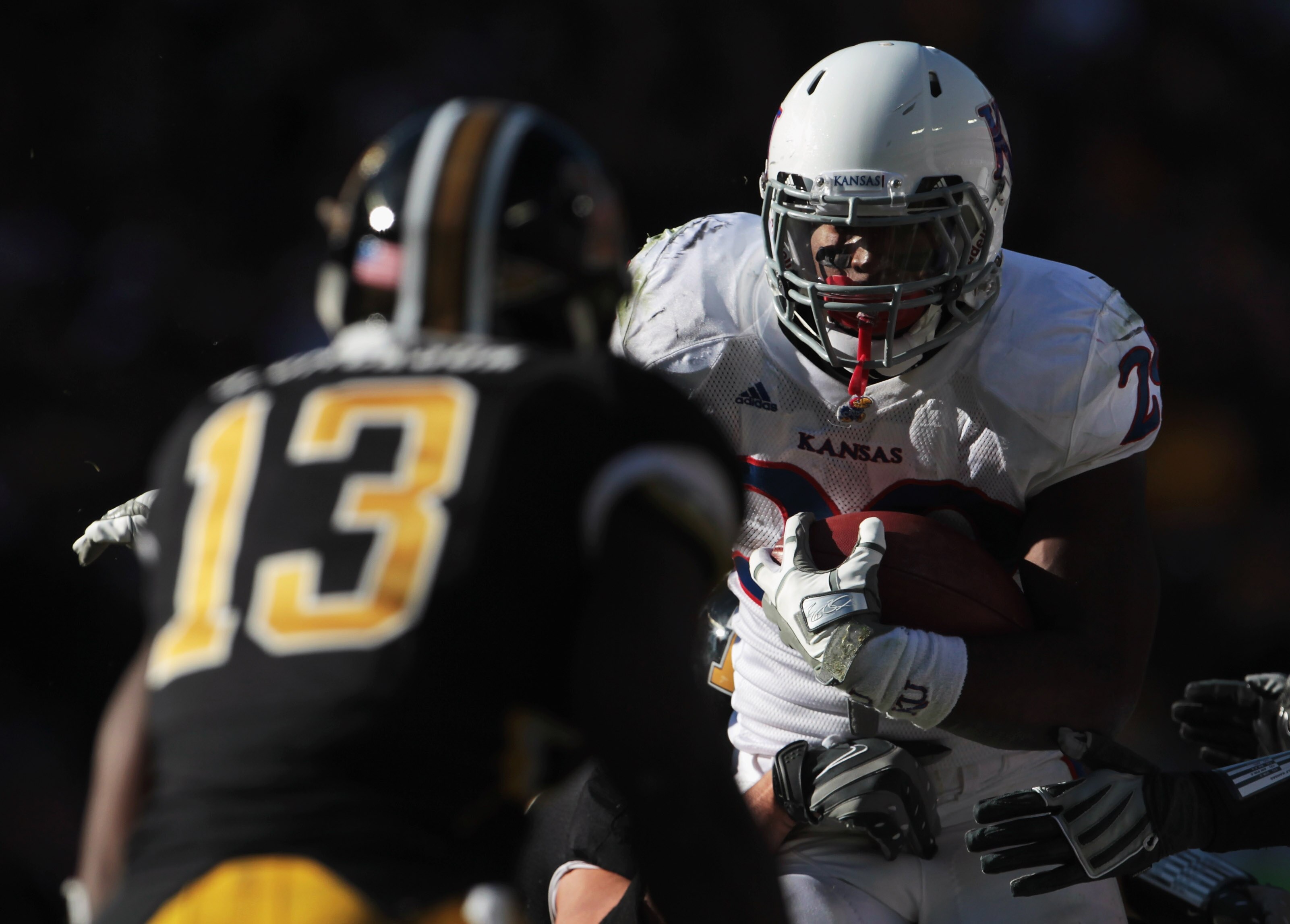 KANSAS CITY, MO - NOVEMBER 27:  James Sims #29 of the Kansas Jayhawks carries the ball as Kenji Jackson #13 of the Missouri Tigers defends during the game on November 27, 2010 at Arrowhead Stadium in Kansas City, Missouri.  (Photo by Jamie Squire/Getty Im