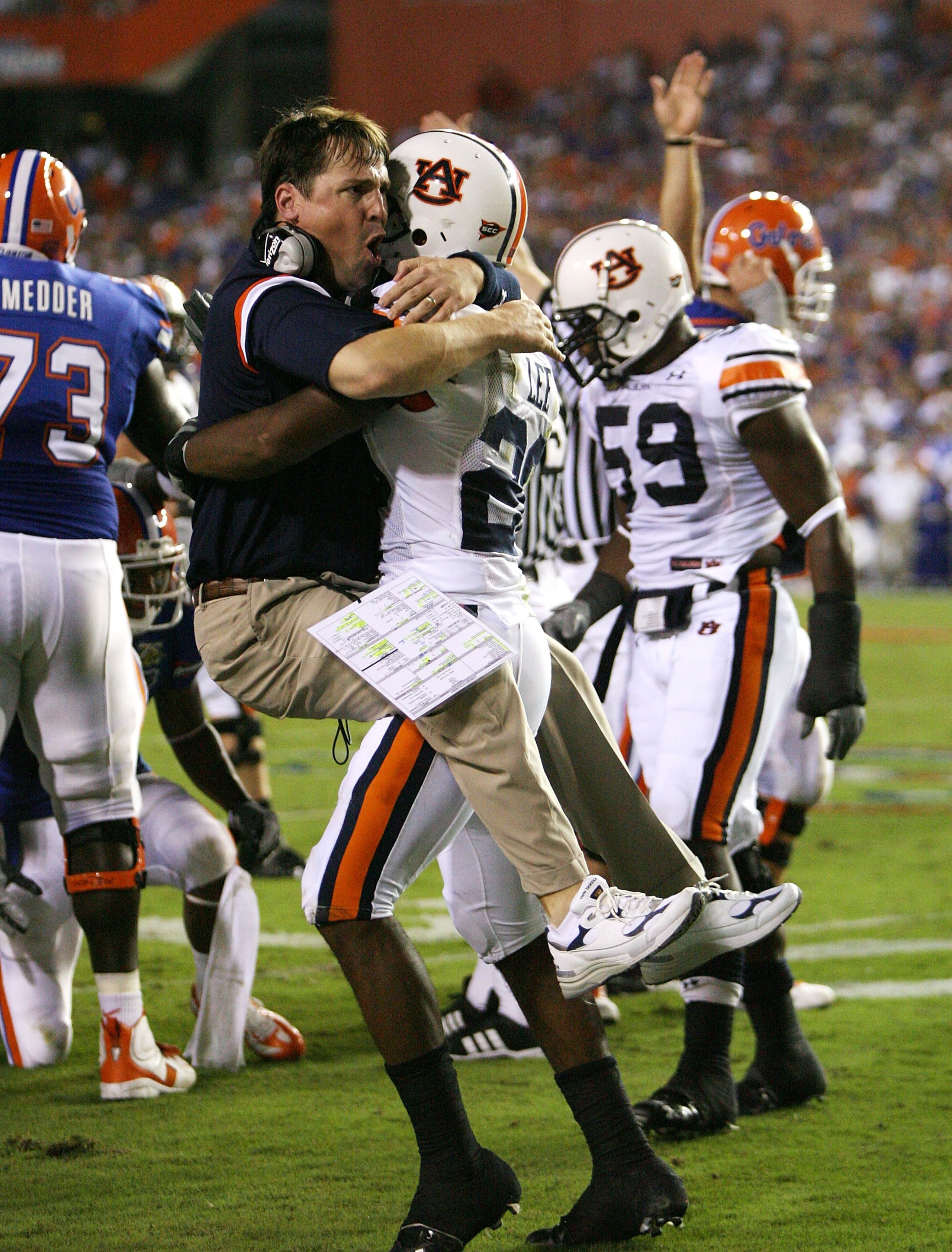 GAINESVILLE, FL - SEPTEMBER 29:  Defensive coordinator Will Muschamp of the Auburn Tigers jumps into the arms of defensive back Patrick Lee #20 after Lee helped cause a fumble late in the first half against the Florida Gators at Ben Hill Griffin Stadium S